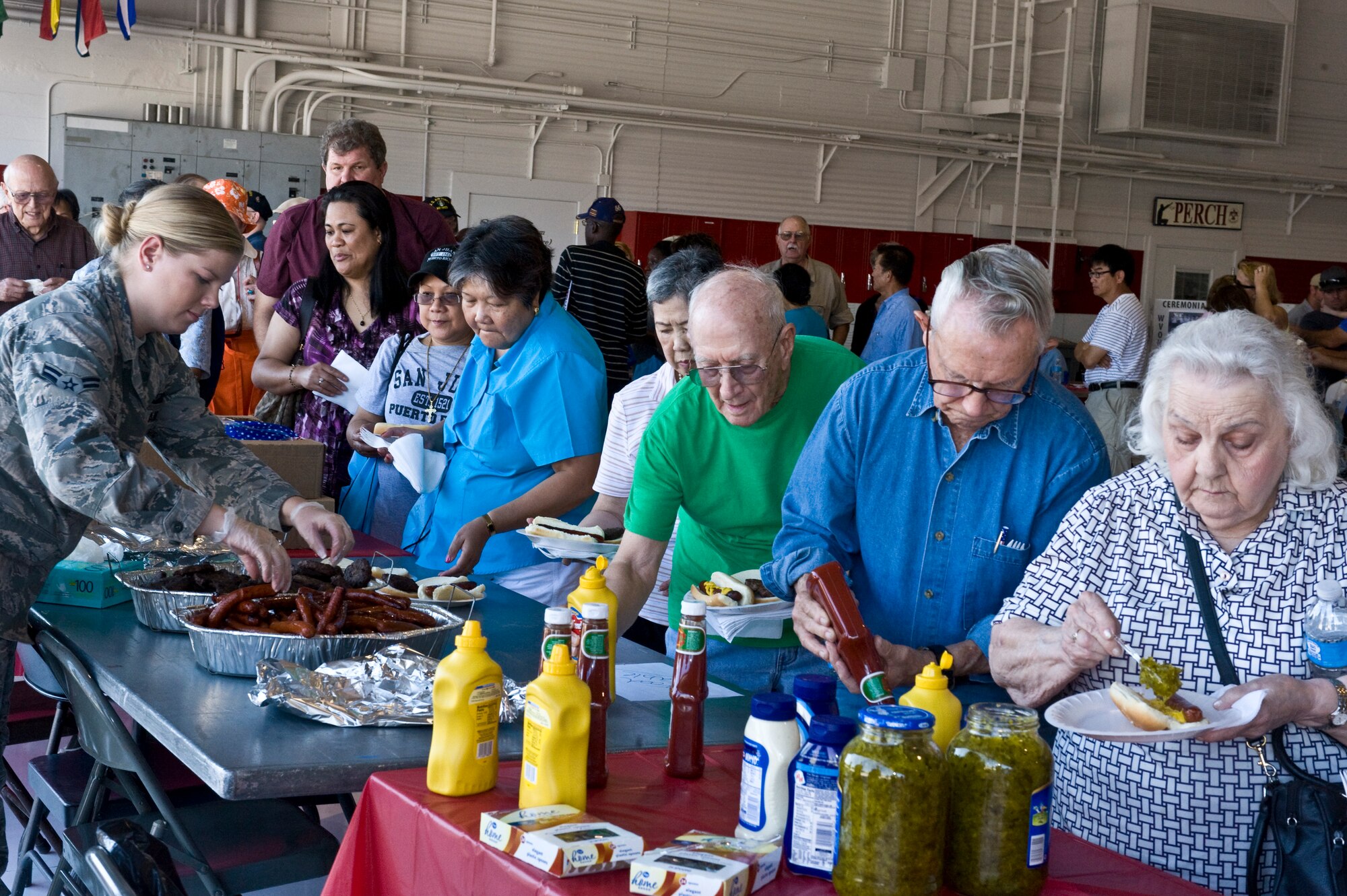 Airman 1st Class Courtney Williams, 99th Comptroller Squadron, serves food to retirees and their families during Retiree Appreciation Day, Sep. 15, 2012, at Nellis Air Force Base, Nev. Approximately 810 individuals attended this year's event, which included military demonstrations, medical resources and entertainment. (U.S. Air Force photo by Airman 1st Class Matthew Lancaster)
