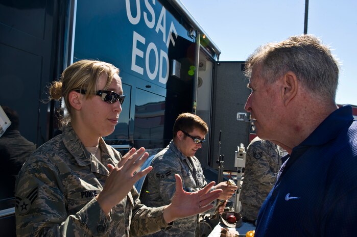 Airman 1st Class Amanda Ponce, 99th Civil Engineer Squadron explosive ordnance disposal technician, talks to Theodore Swenson, United States Air Force retiree, about the EOD suit and  EOD mission during Retiree Appreciation Day Sept. 15,  2012, at Nellis Air Force Base, Nev. Retiree Appreciation Day informs retirees and their families about resources and  give them points of contacts to outside entities that can provide assistance while showing appreciation to those that have served. (U.S. Air Force photo by Airman 1st Class Matthew Lancaster)