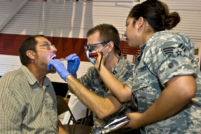 Capt. Nathan Larson, dental resident, and Senior Airman Elizabeth Gonzalez, dental assistant, 99th Dental Squadron, examine Timothy Mancour's teeth during Retiree Appreciation Day, Sept. 15,  2012, at Nellis Air Force Base, Nev. Twenty seven 99th Dental Squadron members provided 150 dental screenings. The staff had a 20 percent increase of individuals seen from the previous year.  (U.S. Air Force photo by Airman 1st Class Matthew Lancaster)