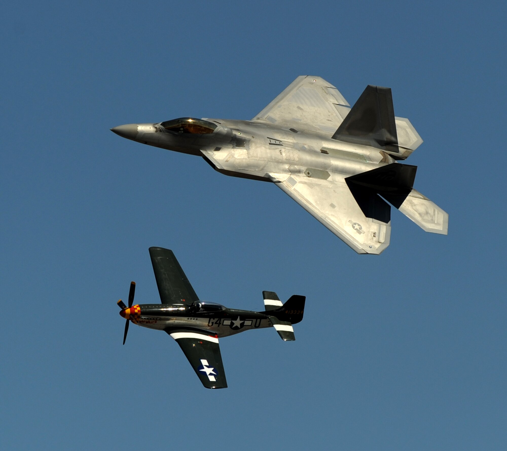 A vintage P-51 Mustang fighter aircraft and a U.S. Air Force F-22 Raptor fighter aircraft perform a heritage flight during the National Championship Air Races at Stead Airport, Reno, Nev., Sept. 14, 2012. The heritage flight program represents the evolution of Air Force airpower by flying today's state-of-the-art fighter aircraft in close formation with a historic fighter. (U.S. Air Force photo by Staff Sgt. Robert M. Trujillo/Released)