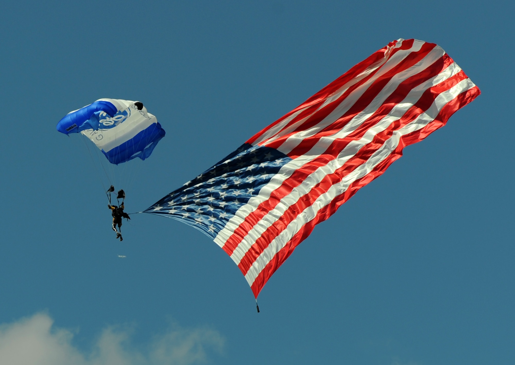 Parachutist Dana Bowman descends with the American Flag during the opening ceremonies of the National Championship Air Races at Stead Airport, Reno, Nev., Sept. 14, 2012. Bowman, a double amputee, was a member of U.S. Army Golden Knights Parachute Team. (U.S. Air Force photo by Staff Sgt. Robert M. Trujillo/Released)