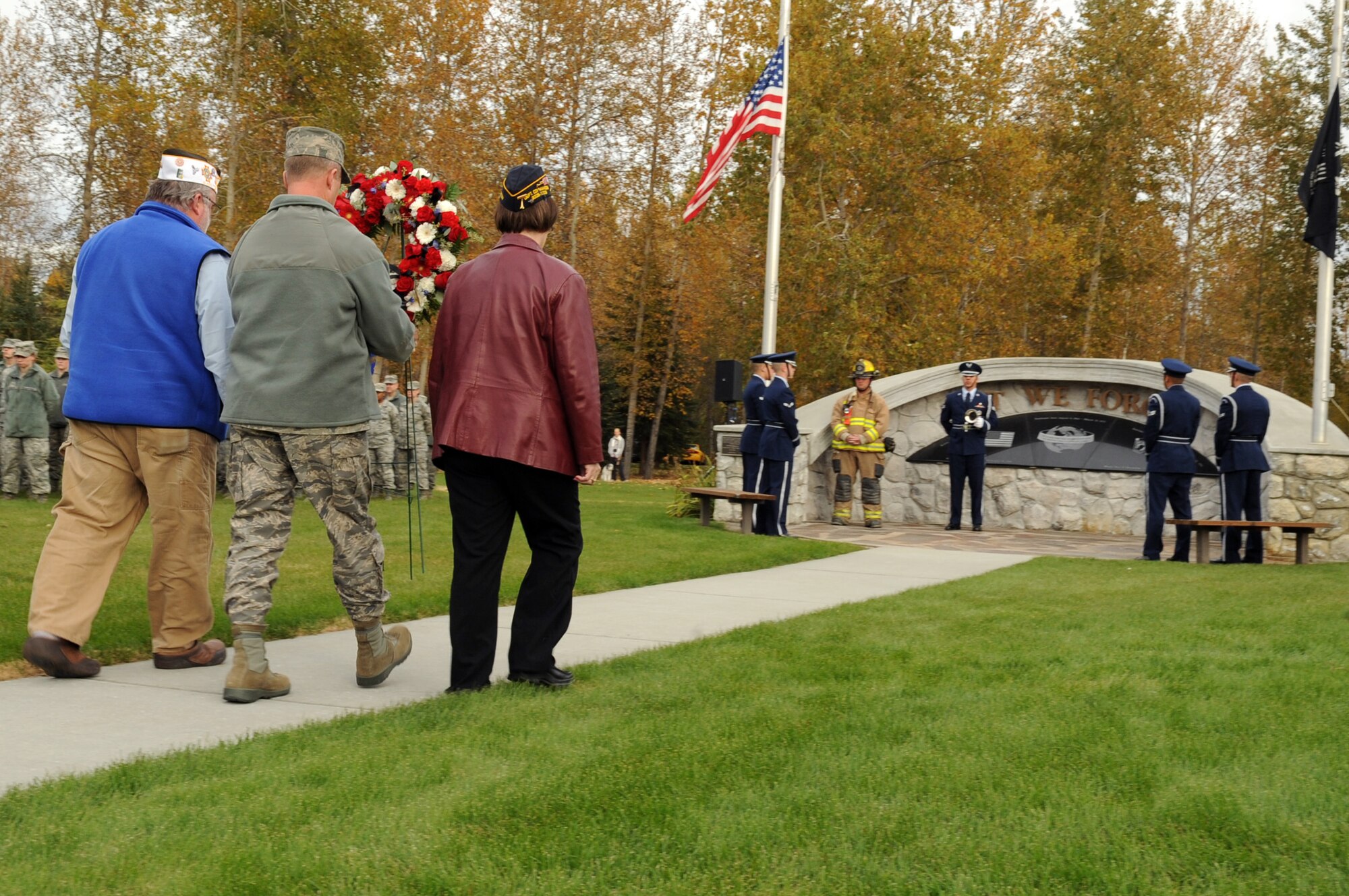 U.S. Air Force Brig. Gen. Mark Kelly, 354th Fighter Wing commander, Mrs. Terry Huisman, founder of The American Legion Riders, and Mr. Dave Lemelin, a Veteran of Foreign Wars member, carries a wreath to the POW/MIA monument at Heritage Park during a POW/MIA retreat ceremony Sept. 14, 2012, Eielson Air Force Base, Alaska. According to the Defense Prisoner of War/Missing Personnel Office, more than 1,700 Americans are still unaccounted for in the course of the Vietnam War to today. (U.S. Air Force photo/Airman 1st Class Lauren-Taylor Garcia)