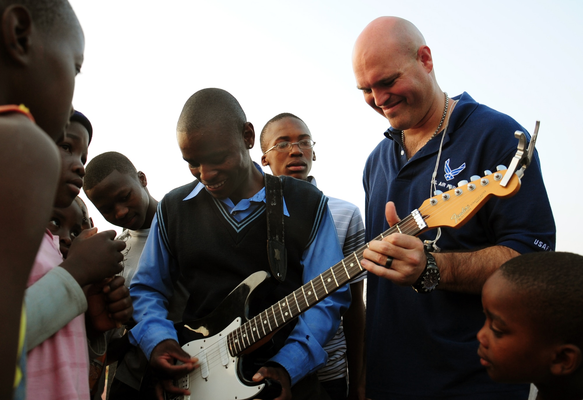 CULLINAN, South Africa -- Tech. Sgt. Jason Cale, U.S. Air Forces in Europe rock band lead guitarist and vocalist, assists Wyvette Sithole with a guitar solo after a performance for the local community here, Sept. 18.  This is the second year Touch ‘n Go has visited the Field Band Foundation and worked with young adults aspiring to become musicians. The foundation is a life skills program which aims to teach young adults to be creative, work together, provides career guidance and discipline, and helps them to empower themselves. (U.S. Air Force photo by Staff Sgt. Debbie Lockhart) 