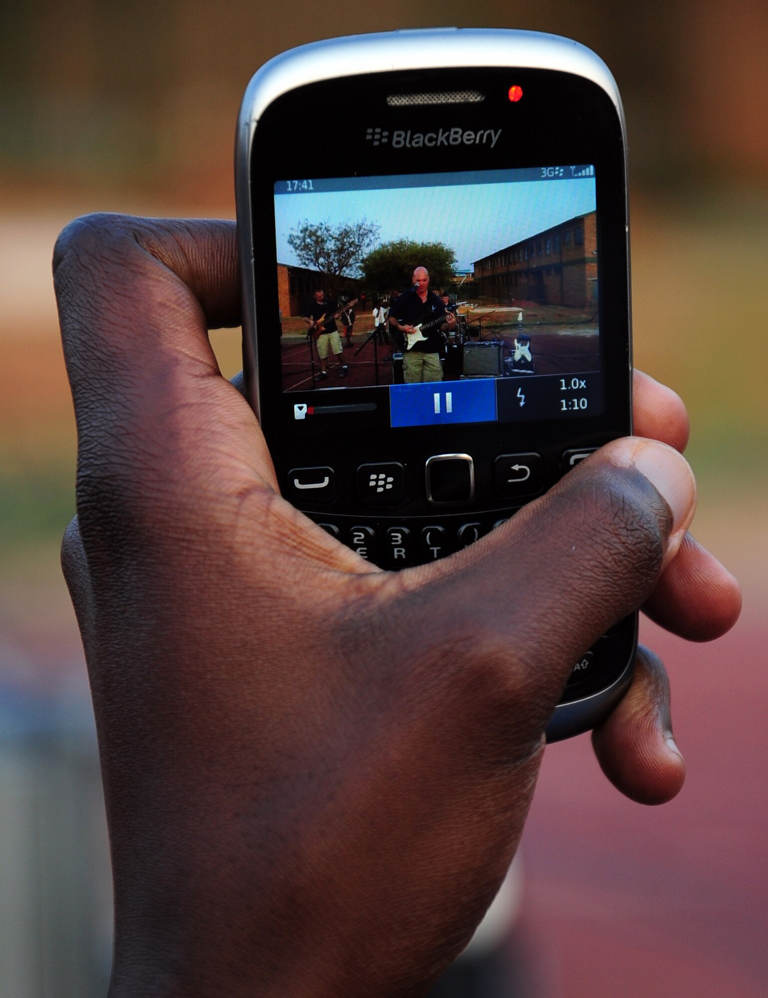 CULLINAN, South Africa -- A student of the De Beers PPC Cullinan field band, records Tech. Sgt. Jason Cale, U.S. Air Forces in Europe rock band lead guitarist and vocalist, on their BlackBerry during a performance here, Sept. 18. The Field Band Foundation is a private organization that has a goal of educating children within the local community on making good decisions, creativity, music and dance and other important life skills. The band, Touch 'n Go, helped bring awareness to the foundation which aims to keep children away from negative influences and encourage them to be successful in life. (U.S. Air Force photo by Staff Sgt. Debbie Lockhart)