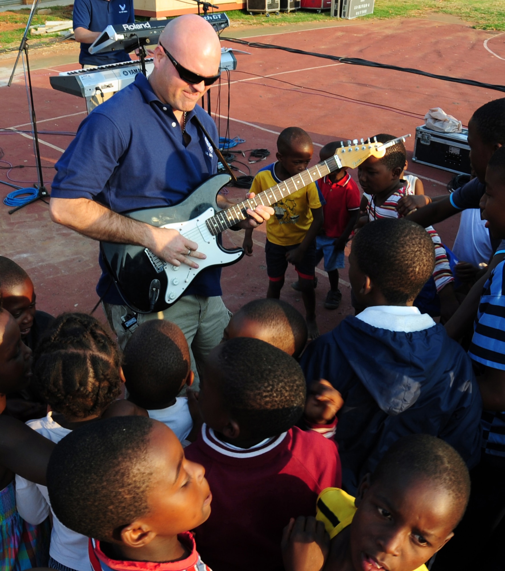 CULLINAN, South Africa -- Tech. Sgt. Jason Cale, U.S. Air Forces in Europe rock band lead guitarist and vocalist, performs a guitar solo in front of children from the local community here, Sept. 18. Touch ‘n Go is here as part of a group of Soldiers, Sailors, Airmen and Marines supporting the Africa Aerospace and Defense Trade show at Air Force Base Waterkloof from Sept. 19-23. As part of their stay, the band visited local communities strengthening the partnership between South Africa and the United States. (U.S. Air Force photo by Staff Sgt. Debbie Lockhart)