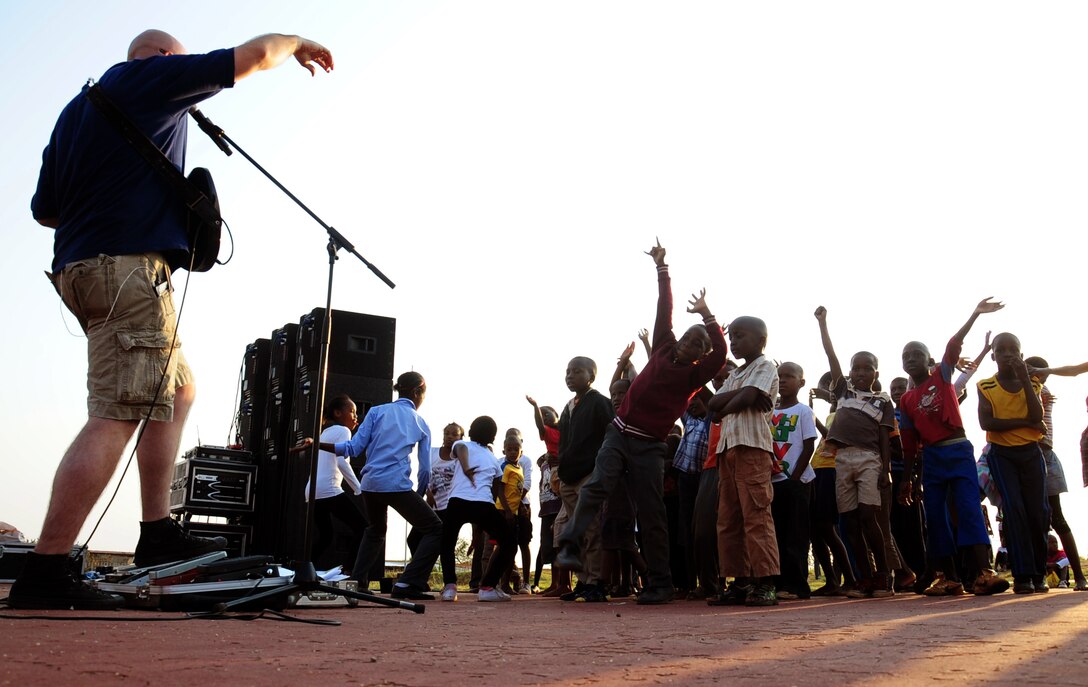 CULLINAN, South Africa -- Tech. Sgt. Jason Cale, U.S. Air Forces in Europe rock band lead guitarist and vocalist, performs a guitar in front of children from the local community here, Sept. 18. The band, Touch ‘n Go, is here as part of a group of Soldiers, Sailors, Airmen and Marines supporting the Africa Aerospace and Defense Trade show at Air Force Base Waterkloof from Sept. 19-23. As part of their stay, the band visited local communities strengthening the partnership between South Africa and the United States. (U.S. Air Force photo by Staff Sgt. Debbie Lockhart)