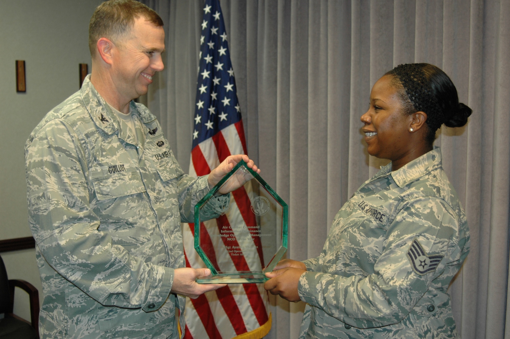 Col. Greg Guillot, 552nd Air Control Wing commander, presents Staff Sgt. Ayanna Thomas with the 2011 Air Combat Command Information Dominance Knowledge Operations Management Noncommissioned Officer of the Year Award prior to his bi-weekly staff meeting on Thursday, Sept. 6 in the 552nd ACW Conference Room. (Air Force photo by Darren D. Heusel)