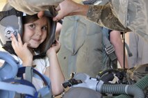 Emma Alexander, the daughter of a deployed Peterson Air Force Base Airman tries on a tactical flight helmet during the Peterson Air Force Base Deployed Family Dinner, sponsored by the Air Force Reserve Command's 302nd Airlift Wing and its active duty associate unit, the 52nd Airlift Squadron. Approximately 100 family members of deployed personnel from throughout Peterson AFB, Colo. attended the Sept 14, 2012 event held in the 302nd AW aircraft maintenance hangar. (U.S. Air Force photo/Ann Skarban)