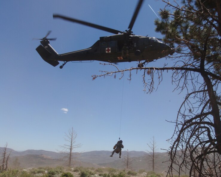 Senior Airman Justin Jessick, 2nd Civil Engineer Squadron Explosive Ordnance Disposal journeyman, is hoisted up by a UH-60 Blackhawk helicopter during Marine Corps Mountain Warfare training in Calif., June 2012. (Courtesy photo)