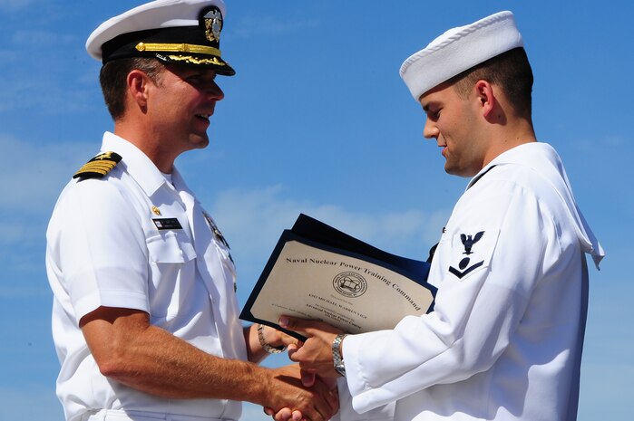 Petty Officer 3rd Class Michael Vige receives the Class Honorman award for Enlisted Class 1203 from Capt. Jon Fahs, Naval Nuclear Power Training Command commanding officer, during the NNPTC graduation ceremony Sept. 14, 2012, at Joint Base Charleston - Weapons Station, S.C. The Honorman award is given to the Sailor with the highest grade point average. Vige's grade point average was 3.96. (U.S. Air Force photo/ Airman 1st Class Chacarra Walker)