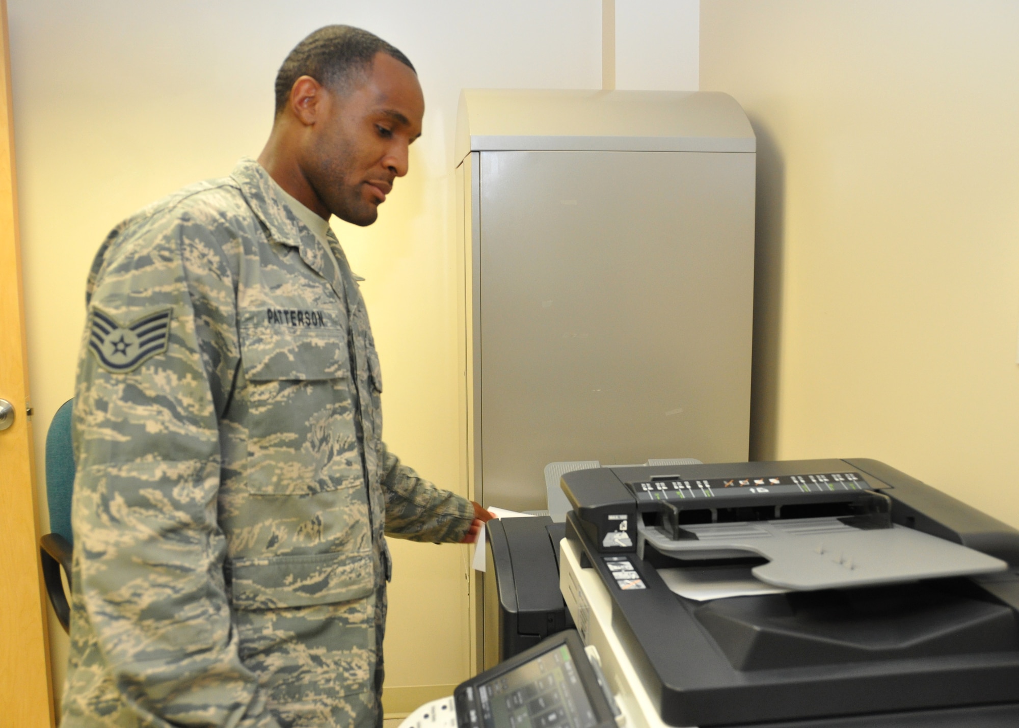 Staff Sgt. Leonard Patterson, 81st Aerospace Medicine Squadron public health technician, retrieves an item from the office copier at Keesler Air Force Base, Miss. Patterson was recently selected to attend Basic Officer Training Spet. 14, 2012, and will go on to be a remotely-piloted aircraft pilot.  (U.S. Air Force photo by Steve Pivnick)