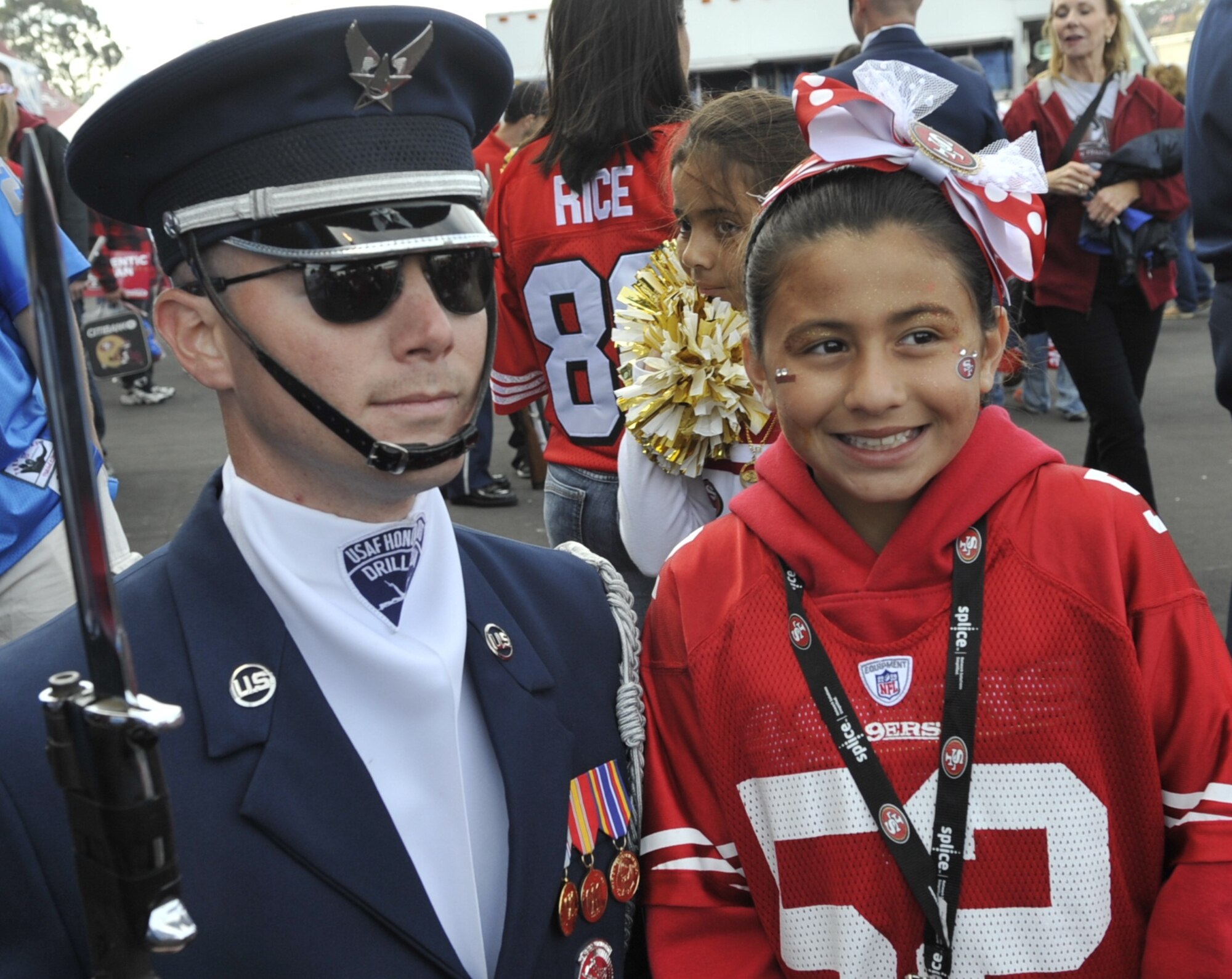 Senior Airman Andrew Winders, U.S. Air Force Honor Guard Drill Team member, poses with a fan following a pre-game performance at the Detroit Lions vs. San Francisco 49ers NFL football game at Candlestick Park in San Francisco, Calif., Sept. 16, 2012.  The Drill Team performed in front of more than 500 people before the game and stood on the field during the National Anthem in front of a sold-out crowd.  (U.S. Air Force photo by Senior Master Sgt. Adam M. Stump)