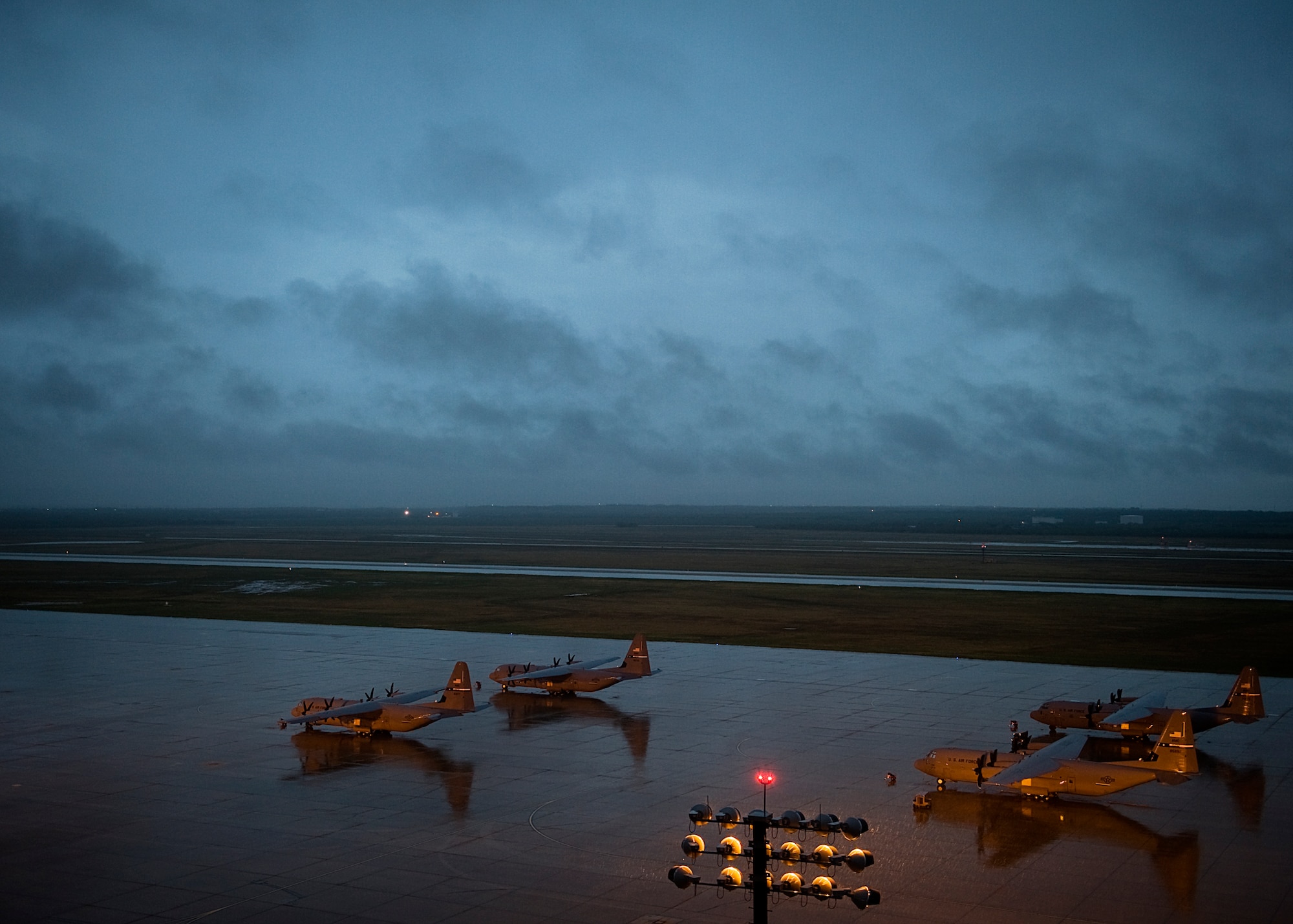 C-130J Super Hercules from the 317th Airlift Group sit on the flightline during a storm Sept. 18, 2012, at Dyess Air Force Base, Texas. Dyess recently received its 23rd of 28 C-130Js. The C-130J incorporates state-of-the-art technology to reduce manpower requirements, lower operating and support costs, and provides life-cycle cost savings over earlier C-130 models. Compared to older C-130s, the J-model climbs faster and higher, flies farther at a higher cruise speed, and takes off and lands in a shorter distance. Once the final aircraft is delivered, Dyess will be home to the largest C-130J fleet in the world. (U.S. Air Force photo by Airman 1st Class Damon Kasberg/ Released)