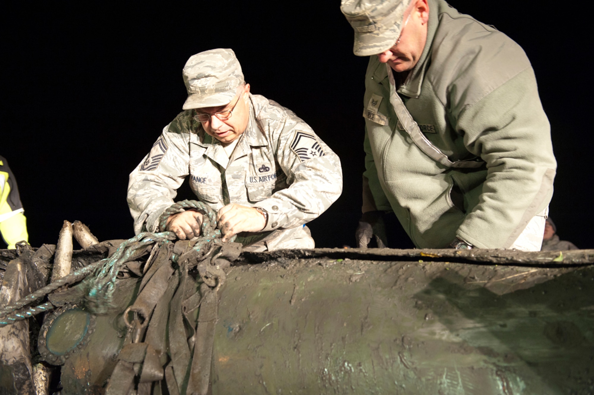JOINT BASE ELMENDORF-RICHARDSON, Alaska -- Senior Master Sgt. Archie Vance (left) unties a rope used to haul the F-4 Phantom fuel tank from the  Port of Anchorage, Sept. 18, 2012. JBER and the Port of Anchorage worked together to safely remove the external fuel tank, which was discovered earlier by Port personnel. F-4s were flown at Elmendorf Air Force Base through 1982. (U.S. Air Force Photo/Airman 1st Class Omari Bernard)