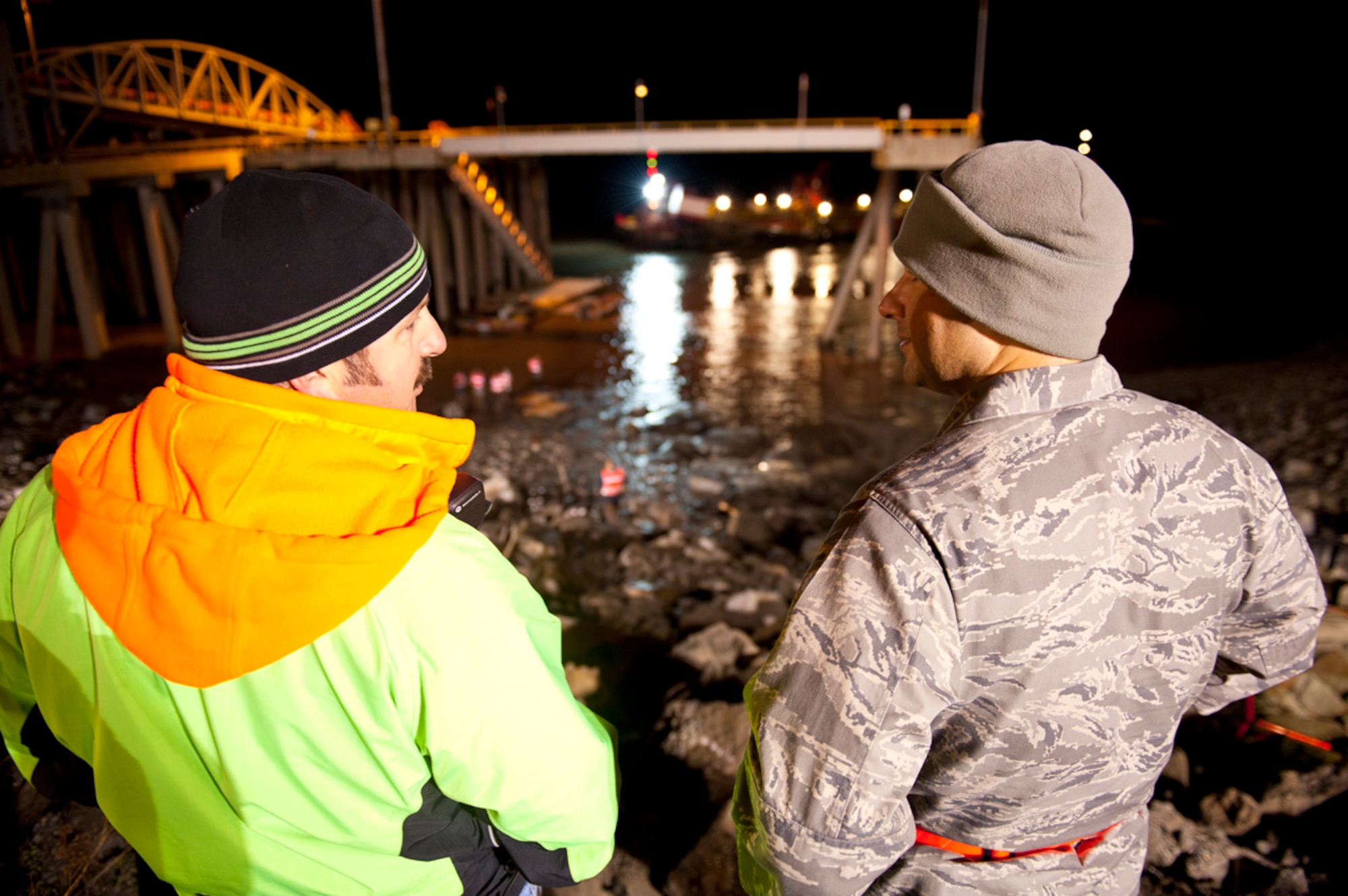 JOINT BASE ELMENDORF-RICHARDSON, Alaska -- Air Force Lt. Col. J. Ramos the commander of the 3d Maintenance Squadron and Paul Rotkus of the Anchorage Port Authority glance at each other breifly as the crash recovery unit locates the F-4 Phantom fuel tank in the Anchorage Port Sept. 18, 2012. The Anchorage Port Authority and the the JBER Crash Recovery Unit under the 3rd MXS are removing an F-4 fuel tank that is embedded in the harbor bank. (U.S. Air Force Photo/Airman 1st Class Omari Bernard)