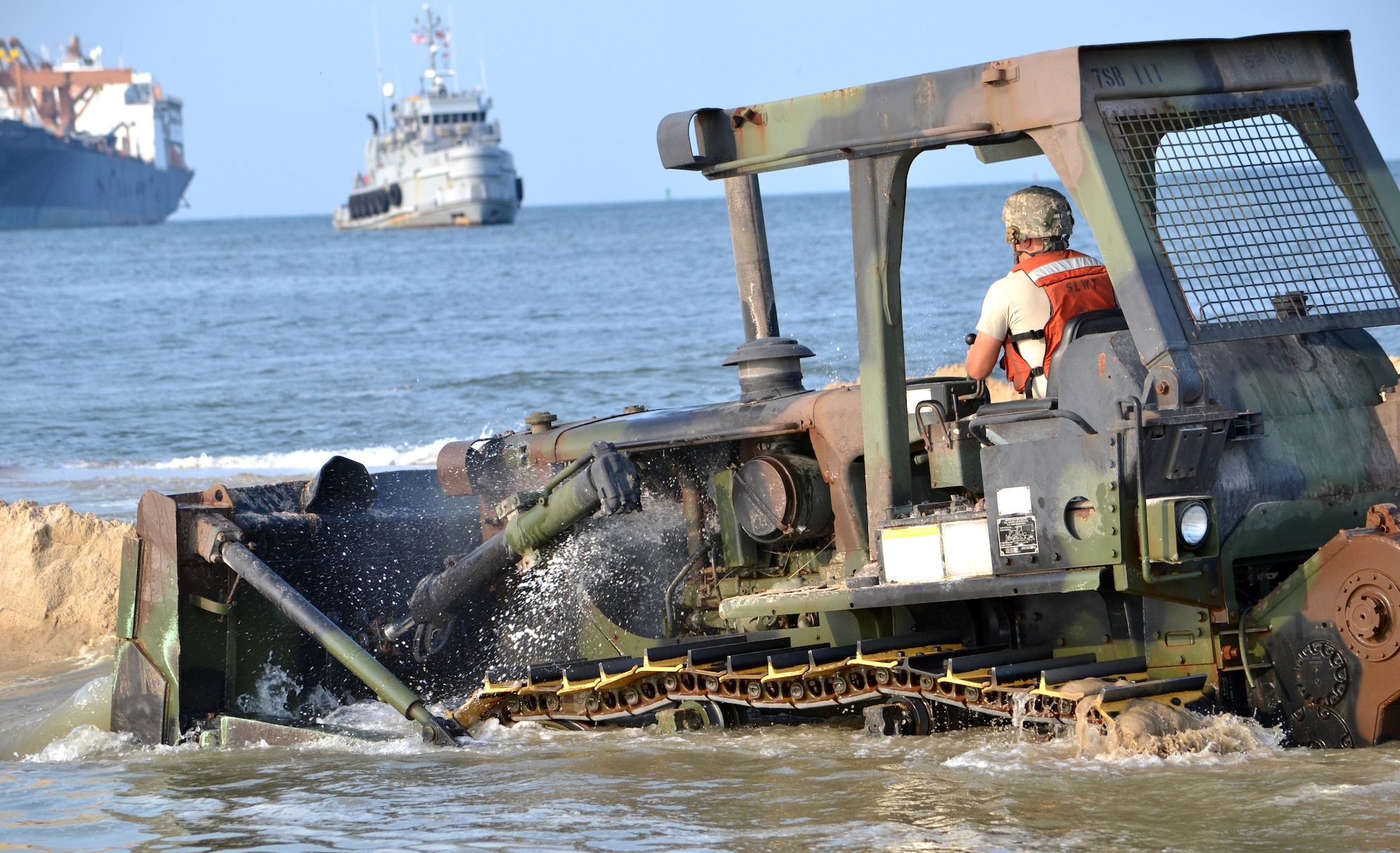 A bulldozer is used to make a duck pond, a water-filled ditch that will allow the pier to extend beyond the shore above the current sea level, before the Trident can attempt to ‘stab the beach’ during the preliminary stages of Joint Logistics-Over-the-Shore exercise Aug.17 at Fort Story. (Courtesy photo)