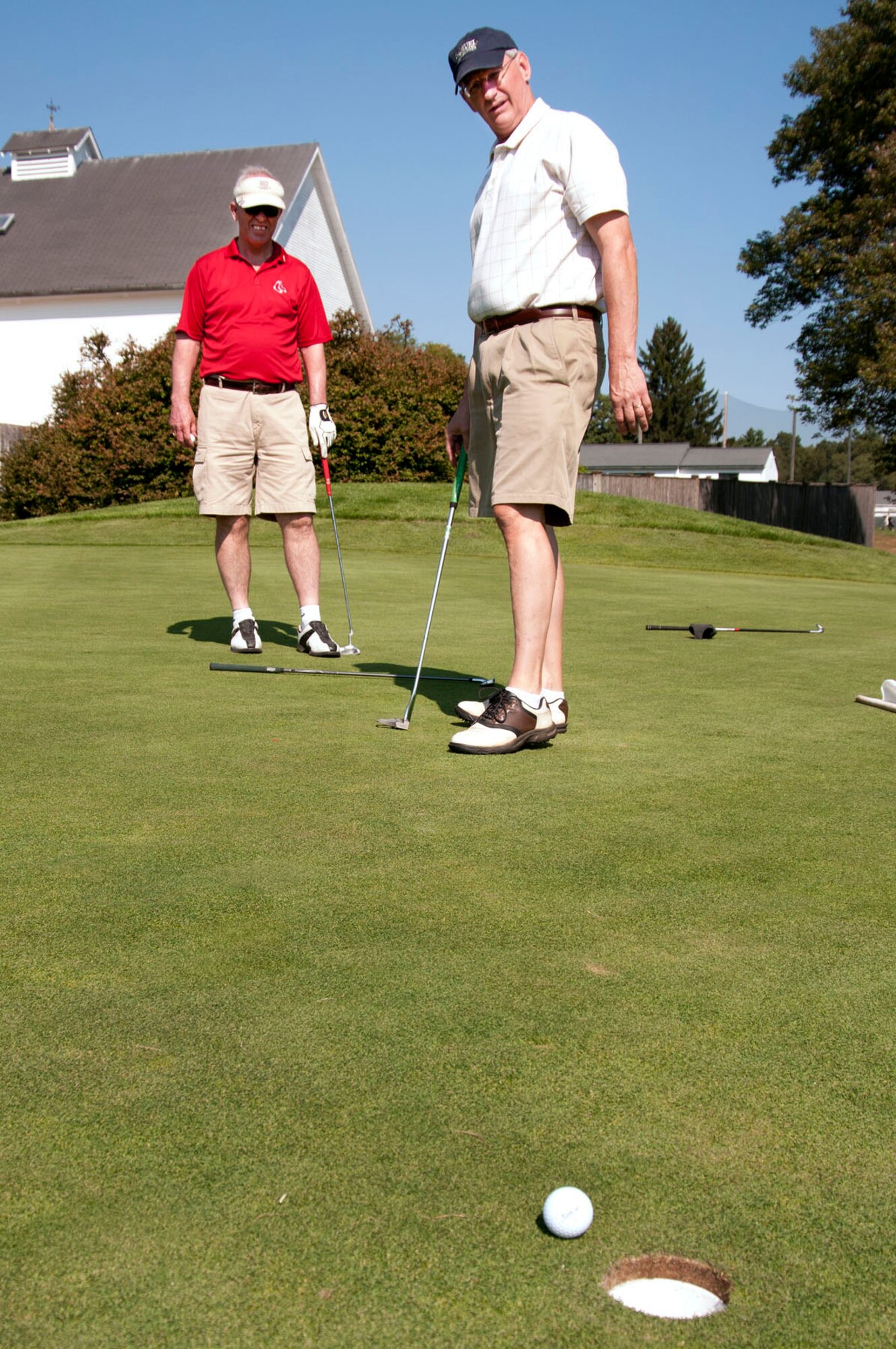 HANSCOM AIR FORCE BASE, Mass. - Chris Perkins (right) watches his putt fall into the hole as Bob Hildreth looks on during the Top 3 and Chief's Group golf tournament at the Patriot Golf Course Sept. 14. Nearly 30 companies and organizations sponsored the fundraising tournament. Money raised will be used to support enlisted personnel from all services in New England throughout the year. (U.S. Air Force photo by Mark Wyatt)