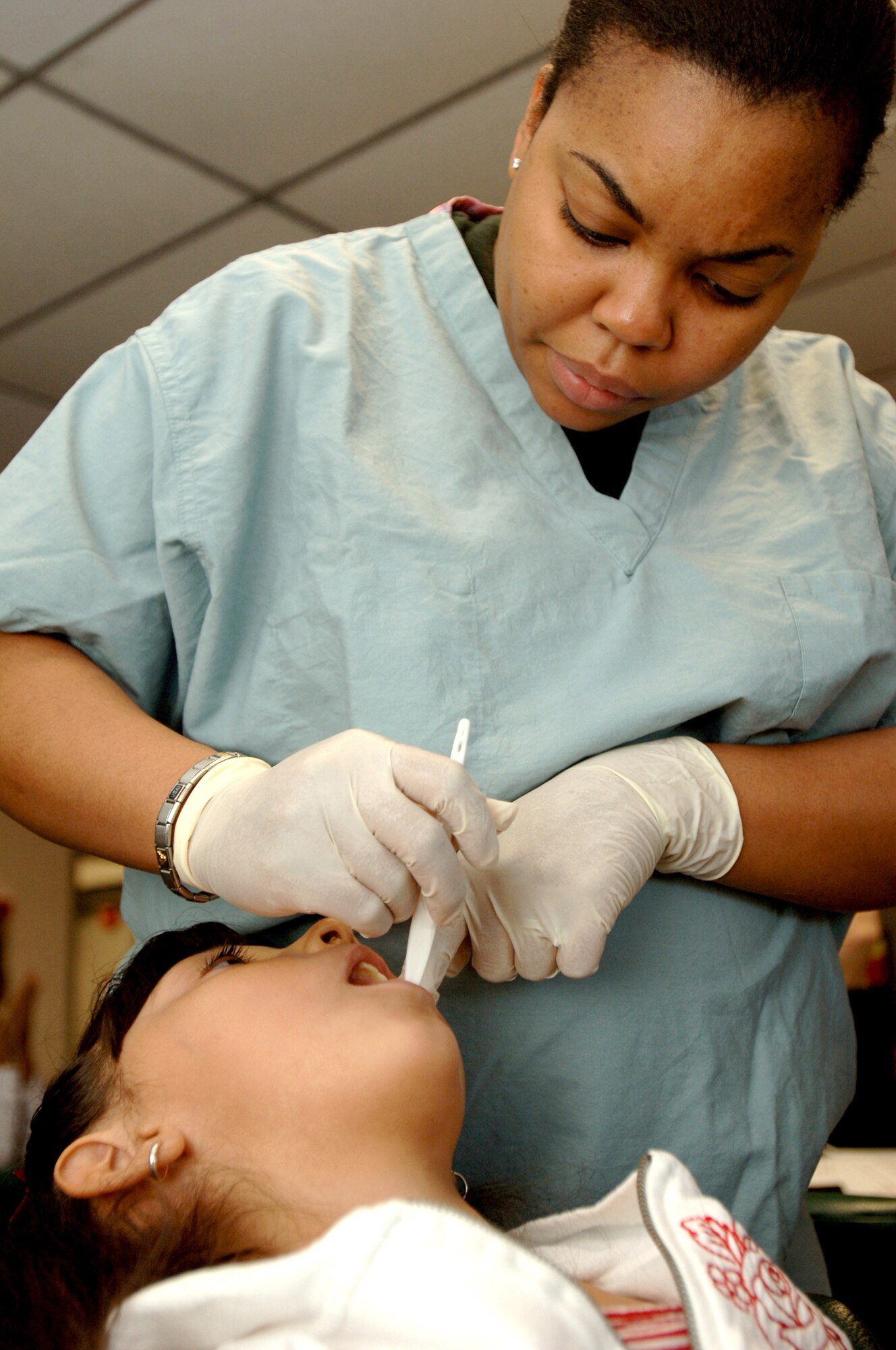 Airman 1st Class Sheryl Dallas, 59th Dental Group dental assistant, examines Destiny Becerra at the drop-in dental clinic on Joint Base San Antonio-Lackland. (U.S. Air Force photo by Senior Airman Erin Peterson)
