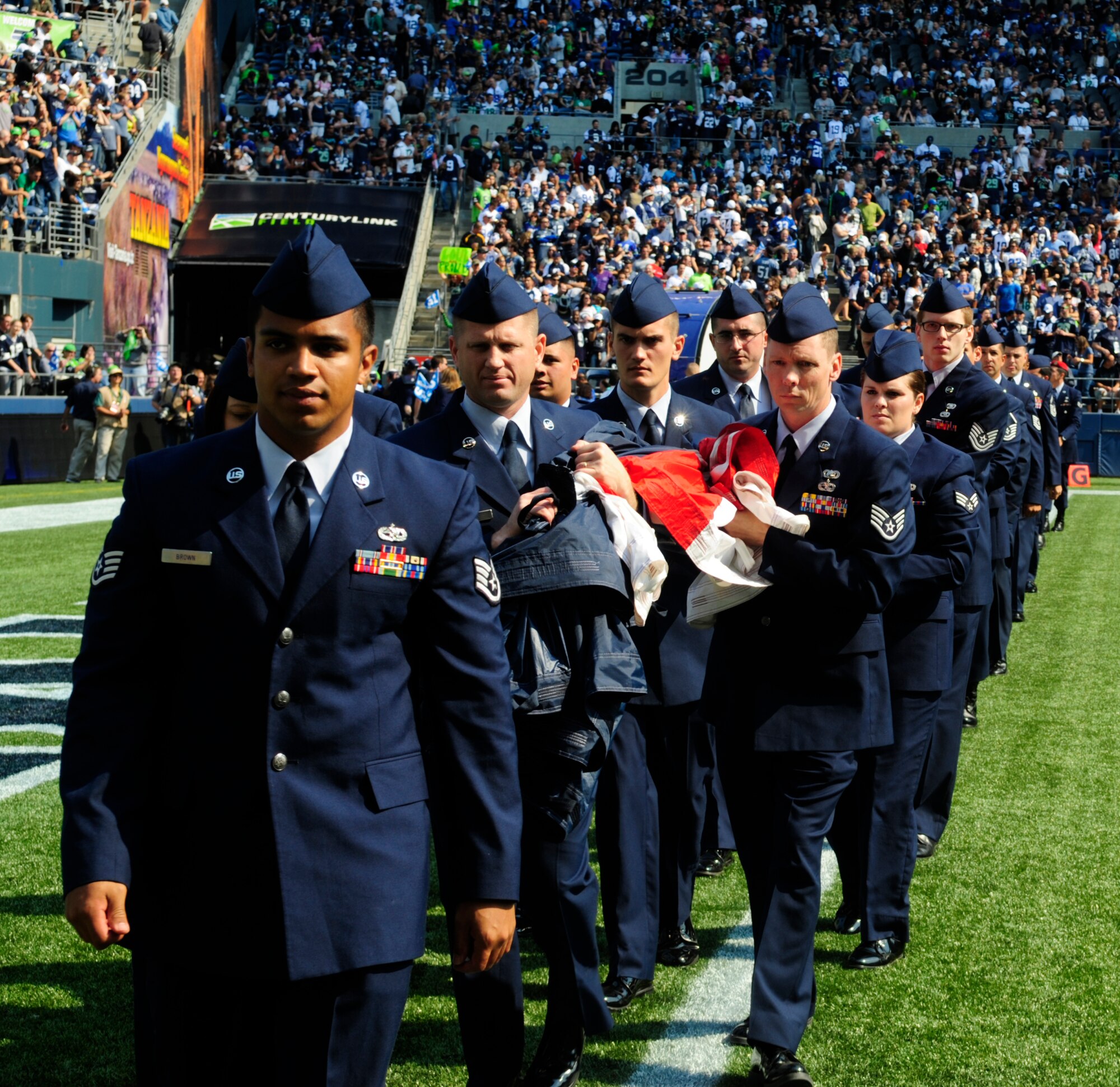 More than 30 U.S. Air Force Airmen from the 62nd and 446th Airlift Wings carry the U.S. flag off the field after unfurling it for the pregame ceremonies for the Sept. 16, 2012 Seattle Seahawks home opener against the Dallas Cowboys at Century Link field in Seattle, Wash. This was the first of three opportunities for the two units to work together in support of the Seattle Seahawks for the 2012 National Football League season. (U.S. Air Force photo/Master Sgt. Todd Wivell)