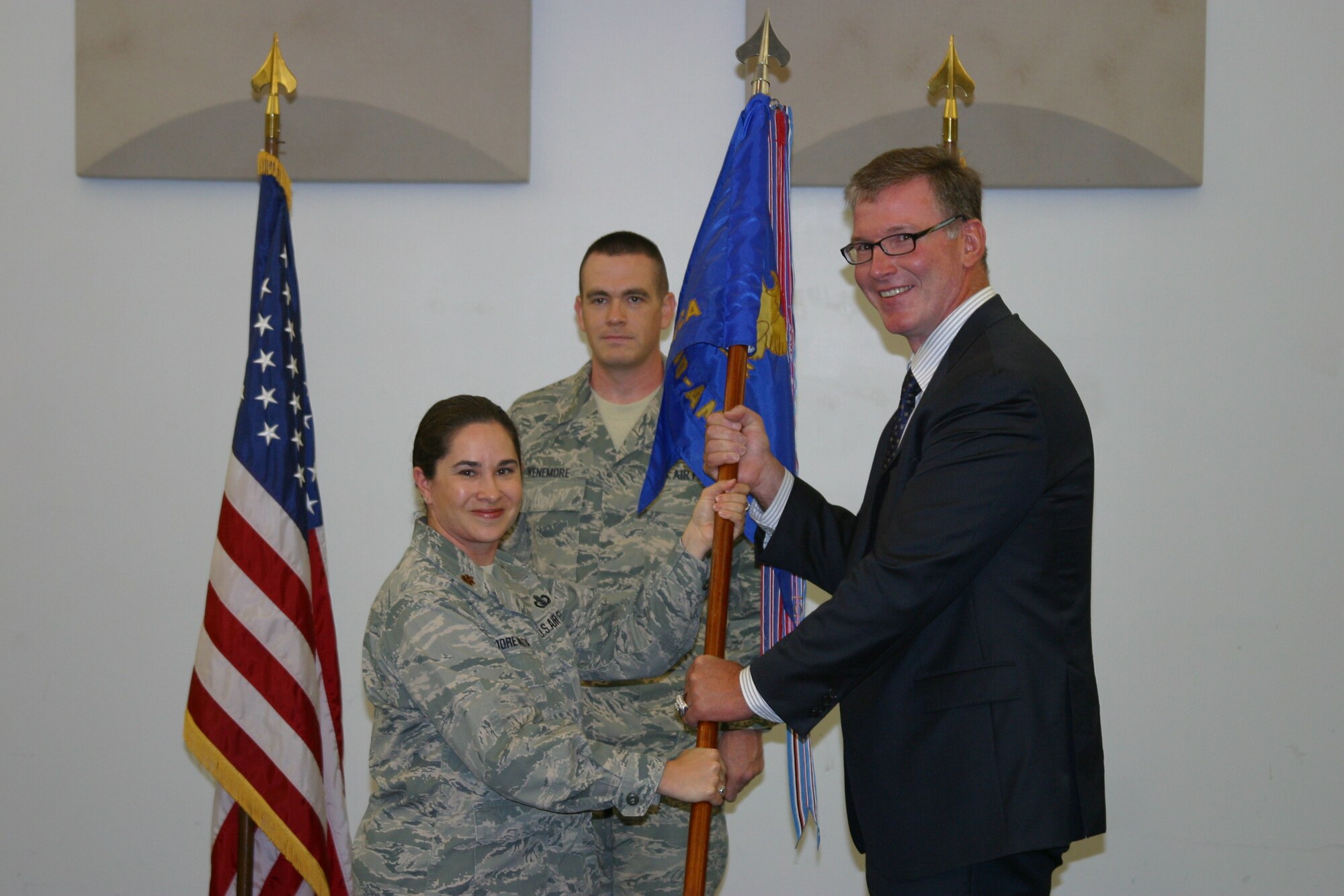 Maj. Cristina Moore Urrutia, U.S. Air Force Band of Mid-America commander, presents the band guidon to Jim Cornelison signifying the start of his tenure as the band's honorary commander during a ceremony at Scott AFB, Ill., Sept. 12, 2012. Cornelison is the national anthem singer for the Chicago Blackhawks professional hockey team. In addition to the ceremony, Cornelison spent the day learning about the missions and capabilities of Air Mobility Command and the Band of Mid-America. 