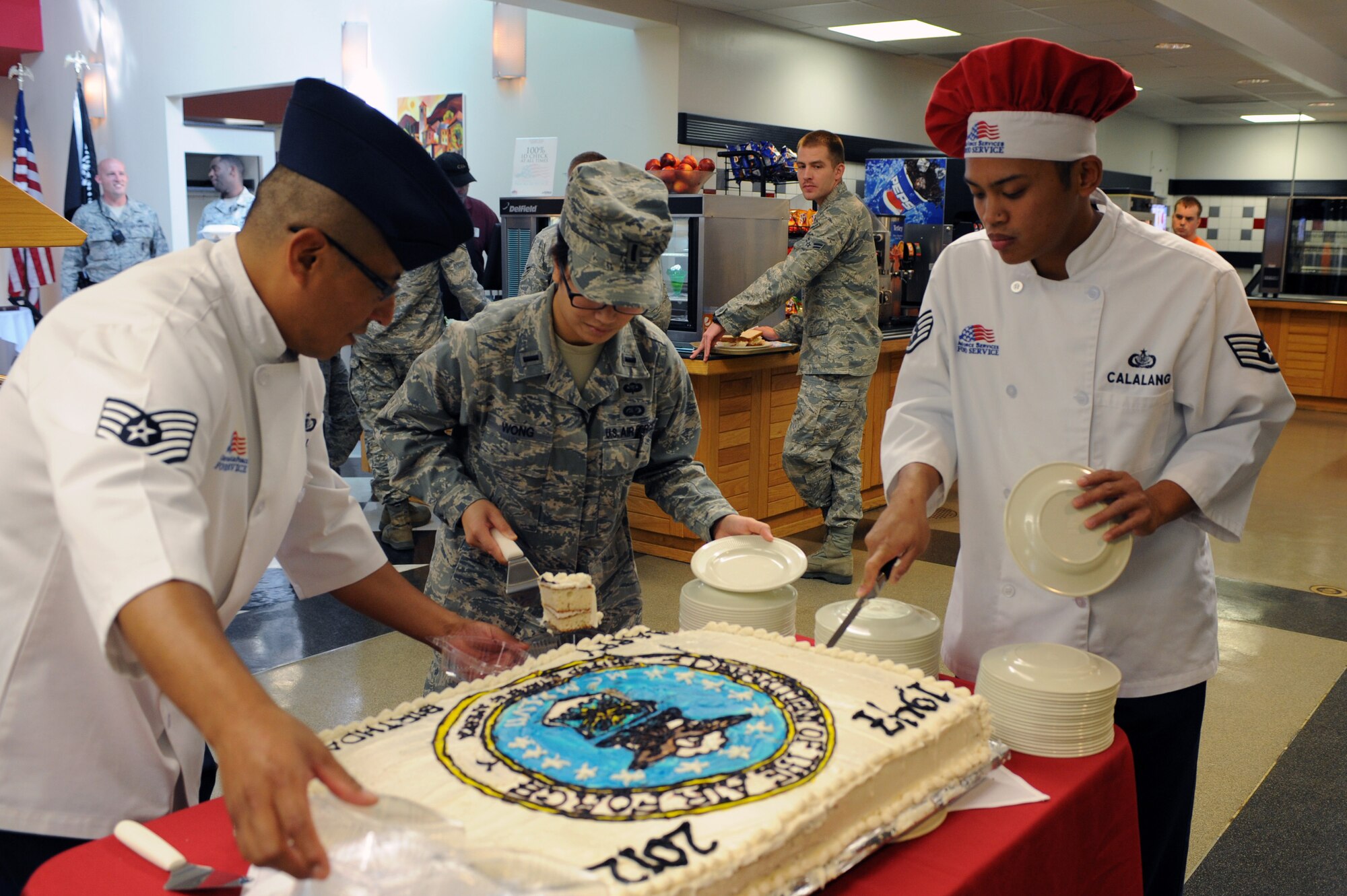 WHITEMAN AIR FORCE BASE, Mo., -- Tech. Sgt. Juan Valle, 1st Lt. Diana Wong and Staff Sgt. Jerry Calalang, from the Force Support Squadron, cut and serve cake at the Ozark Inn dining facility during a celebration of the Air Force?s 65th birthday, Sept. 18. (U.S. Air Force photo/Staff Sgt. Jason Huddleston) (Released)

