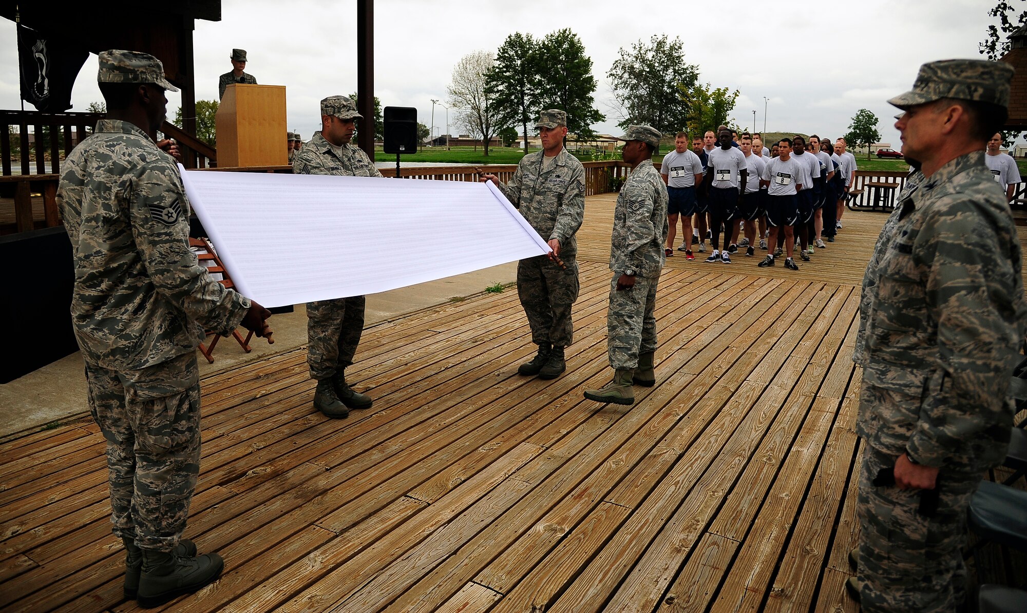 Members of Team Whiteman display a scroll with the names of all those who have been prisoners of war or gone missing-in-action as a U.S. service member since WWI, during the opening ceremony of a POW/MIA run at Whiteman Air Force Base, Mo., Sept. 13. The scroll was rolled and put in a case to be carried by a runner at all times throughout the 24-hour POW/MIA run. (U.S. Air Force photo/ Senior Airman Cody H. Ramirez)  