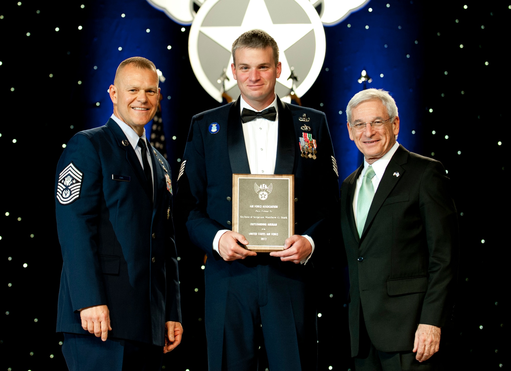Chief Master Sgt. of the Air Force James Roy, left, and Sandy Schlitt, right, Air Force Association's chairman of the board, present a plaque to Tech. Sgt. Matthew Stark during the 12 Outstanding Airmen of the Year reception and awards dinner in Washington, D.C., Sept. 17, 2012. The recipients were recognized for superior leadership, job performance, community involvement and personal achievements. Stark is with the 354th Fighter Wing from Eielson Air Force Base, Alaska. (U.S. Air Force photo/Jim Varhegyi)