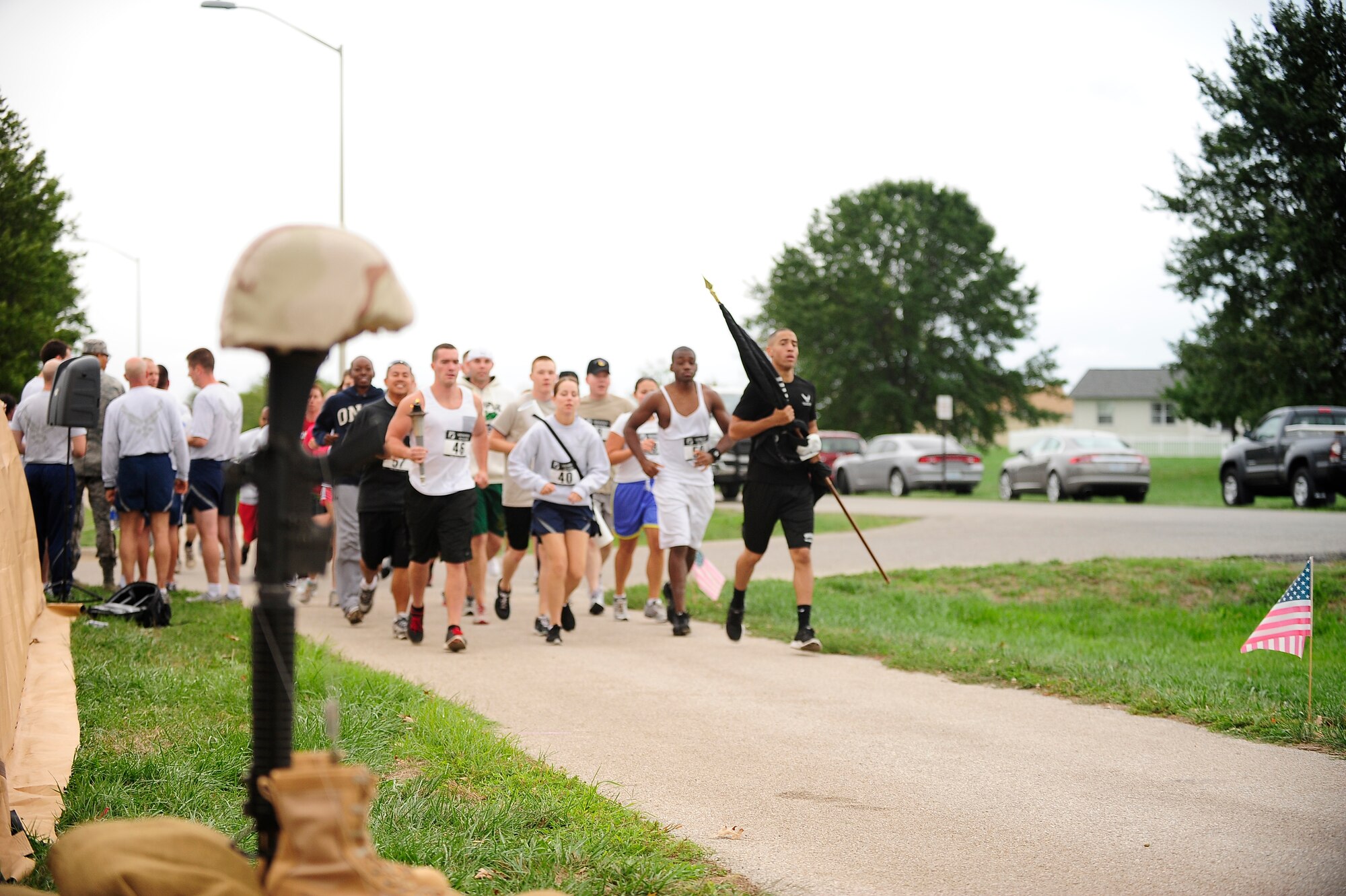 Members of the 509th Medical Group run pass a military memorial representing a fallen service member and those who have gone missing-in-action during the POW*MIA run, Sept. 13. The 24-hour prisoner of war and missing-in-action run was supported by 18 base units in honor those who have been POWs or MIAs, and their families. (U.S. Air Force photo/ Senior Airman Cody Ramirez)