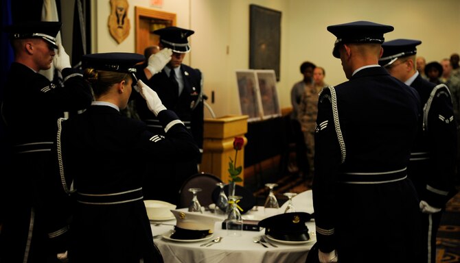 Honor Guard members salute empty spots representing those who could not be there during a prisoner of war and missing-in-action breakfast at Whiteman Air Force Base, Mo., Sept. 14. The POW/MIA breakfast showed respect and support to those who have sacrificed for our country and the families they may have left behind. (U.S. Air Force photo/Senior Airman Cody H. Ramirez) (RELEASED)