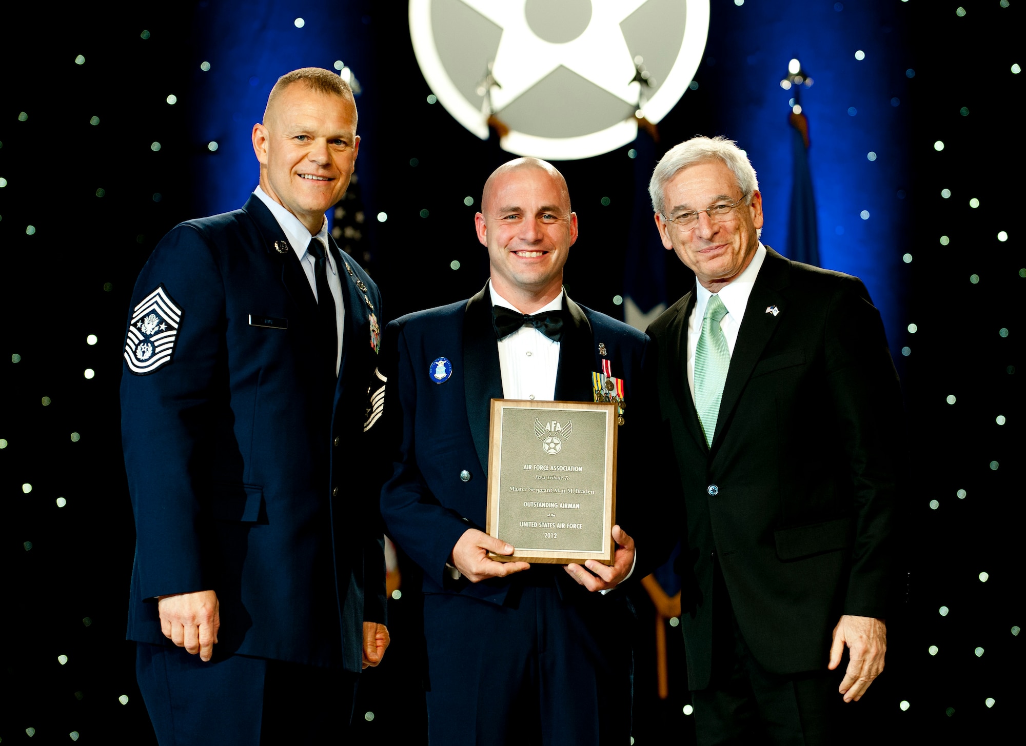 Chief Master Sgt. of the Air Force James Roy, left, and Sandy Schlitt, right, Air Force Association chairman of the board, present a plaque to Master Sgt. Alan Braden during the 12 Outstanding Airmen of the Year reception and awards dinner in Washington, D.C., Sept. 17, 2012. The recipients were recognized for superior leadership, job performance, community involvement and personal achievements. Braden is with the 88th Force Support Squadron from Wright-Patterson Air Force Base, Ohio. (U.S. Air Force photo/Jim Varhegyi)