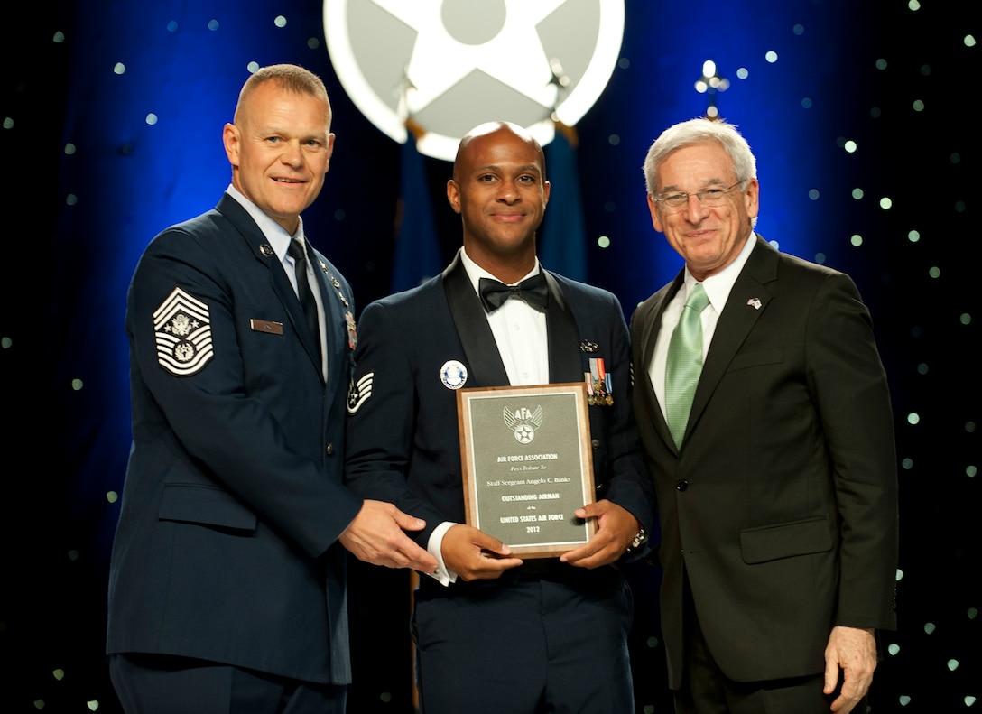 Chief Master Sgt. of the Air Force James Roy, left, and Sandy Schlitt, right, Air Force Association chairman of the board, present a plaque to Staff Sgt. Angelo Banks during the 12 Outstanding Airmen of the Year reception and awards dinner in Washington, D.C., Sept. 17, 2012. The recipients were recognized for superior leadership, job performance, community involvement and personal achievements. Banks is with the 81st Security Forces Squadron from Keesler Air Force Base, Miss. (U.S. Air Force photo/Jim Varhegyi)