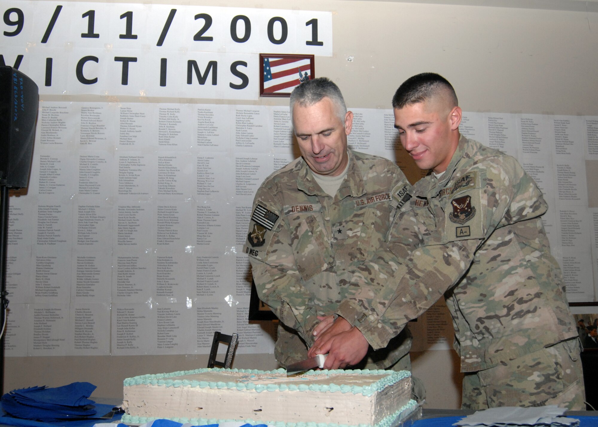 Brig. Gen. Scott Dennis, Kandahar Airfield and 451st Air Expeditionary Wing, commander, and Airman 1st Class Josiah Hewitt, 451st Expeditionary Maintenance Squadron, cut the cake during the 65th Anniversary of the Air Force commemoration here Sept. 18. It is tradition for the most senior Air Force member and the most junior Air Force member attending to perform the honor. (U.S. Air Force photo/Master Sgt. Russell Martin/RELEASED)