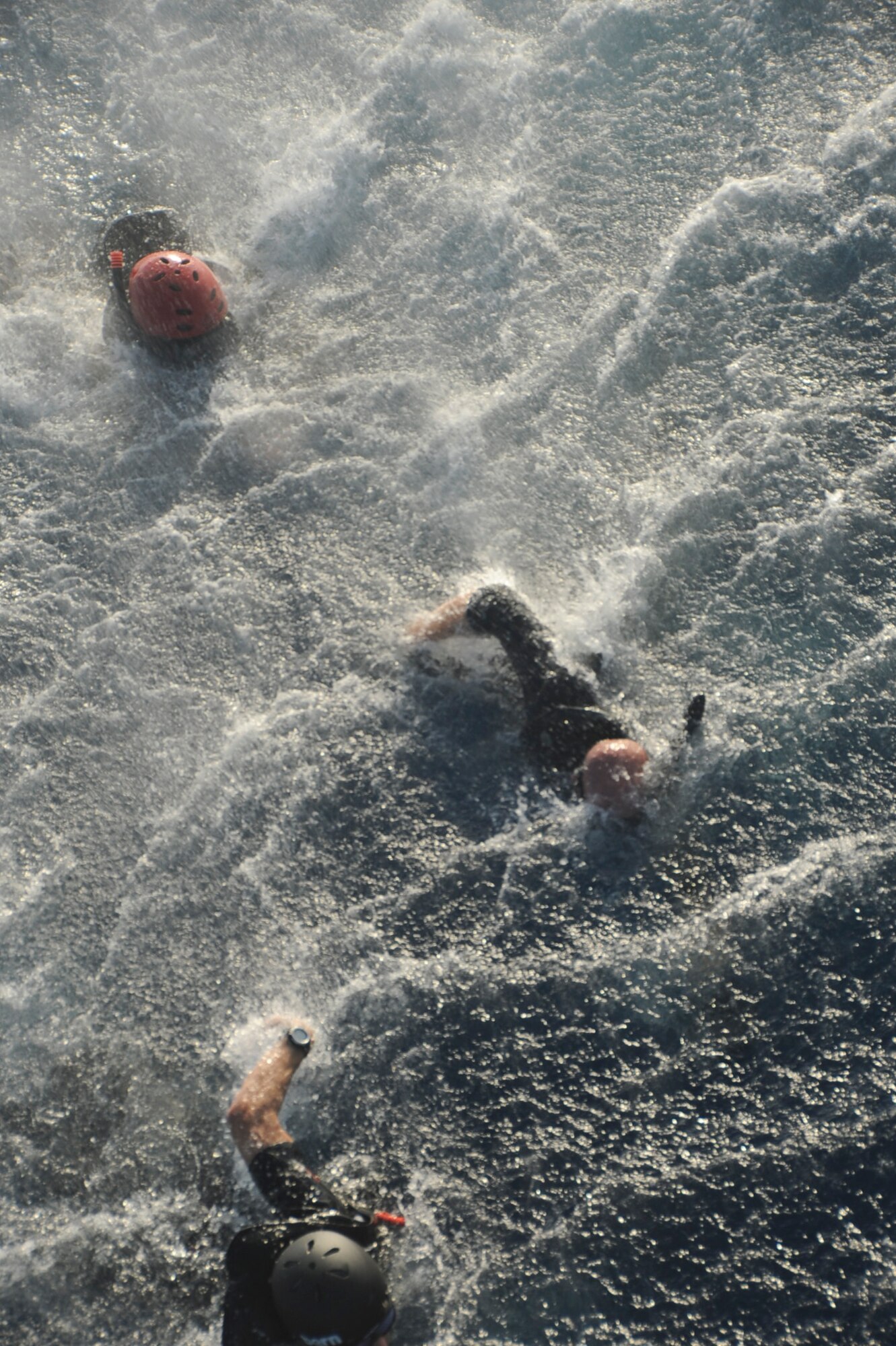 U.S. Air Force Pararescuemen with the 31st Rescue Squadron, swim toward a U.S. Air Force HH-60 Pavehawk helicopter after jumping out during a combined training exercise with the 33rd Rescue Squadron on Okinawa, Japan, Sept. 19, 2012. The PJs train with the 33rd RSQ at least once a week to maintain standards. (U.S. Air Force photo/Airman 1st Class Brooke P. Beers)