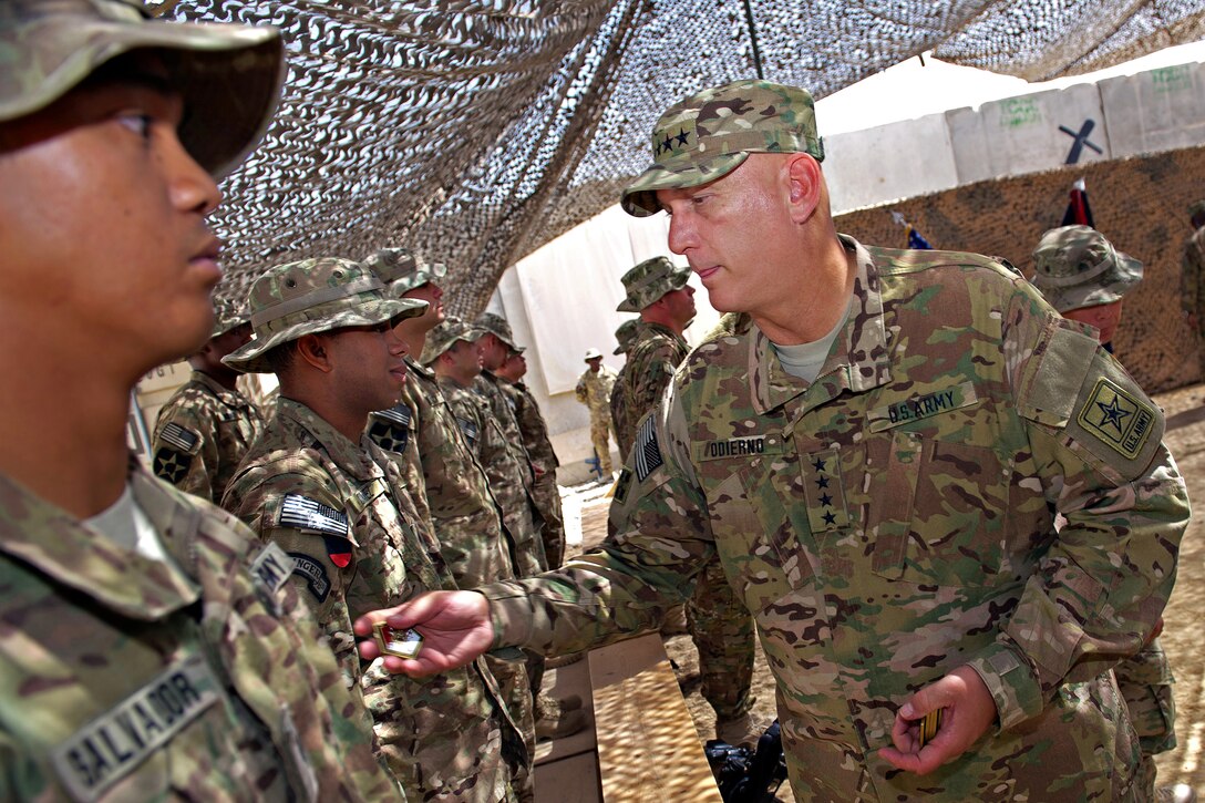 U.S. Army Chief of Staff Gen. Ray Odierno presents coins for excellence to soldiers after hosting their re-enlistment ceremony on Forward Operation Base Zangabad, Afghanistan, Sept. 18, 2012.