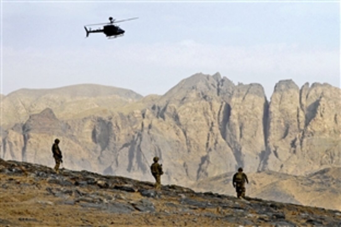 U.S. Army Pfc. Michael Weymouth, left, and Sgt. Christopher Ouzts, center, provide dismounted security for U.S. Air Force Tech. Sgt. Michael Myers, right, and his military working dog, Rambo, in front, while clearing a hill of improvised explosive device threats along a route during Operation Southern Strike III in the Takhteh Pol district of Afghanistan's Kandahar province, Sept. 7, 2012. Weymouth and Ouzts are combat engineers assigned to the 569th Engineer Company.