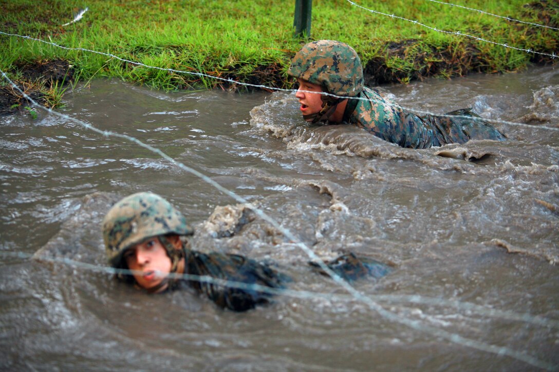 Troops with Landing Support Company, Combat Logistics Regiment 27, 2nd Marine Logistics Group crawl in the water under a barbed wire obstacle during the endurance course at Battle Skills Training School aboard Camp Lejeune, N.C., Sept. 14, 2012. Servicemembers had to cross the muddy water in order to move on to other obstacles and finish the three-mile endurance course. 