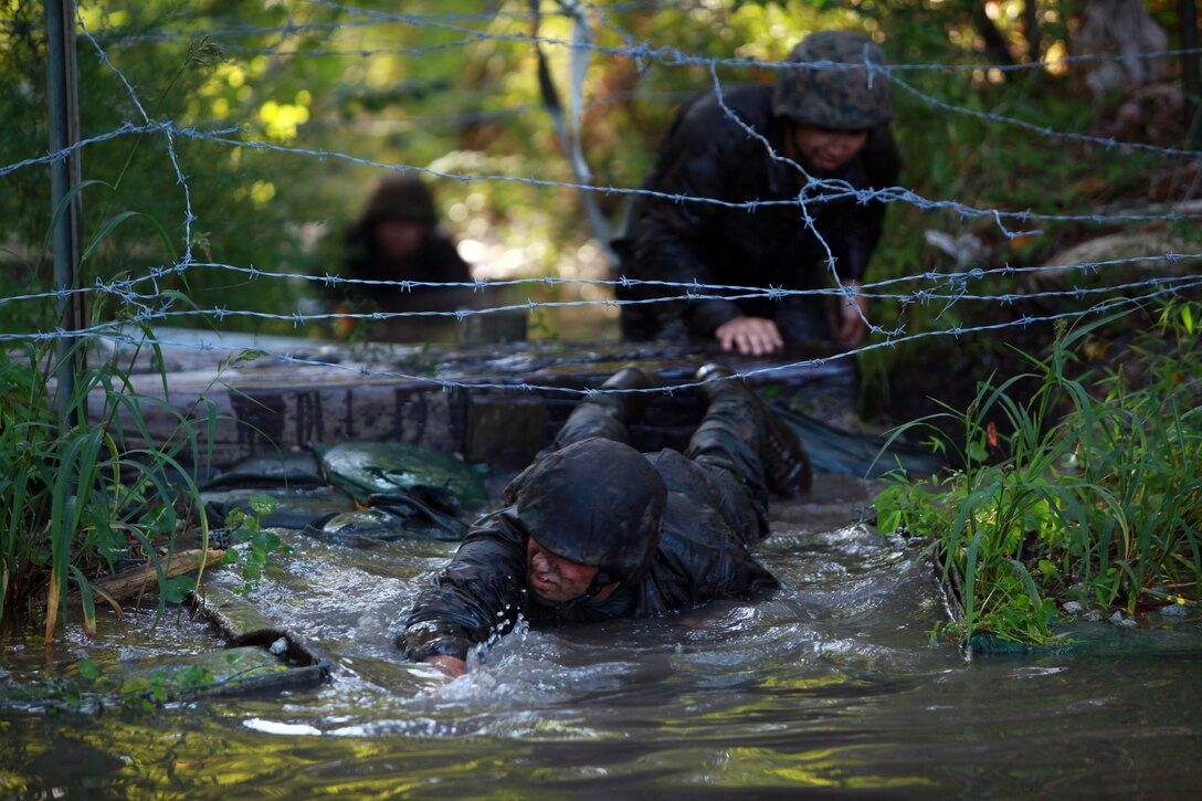 Marines with Landing Support Company, Combat Logistics Regiment 27, 2nd Marine Logistics Group crawl under barbed wire to get to the finish line during the endurance course at Battle Skills Training School aboard Camp Lejeune, N.C., Sept. 14, 2012. Servicemembers finally reached the finish line after nearly an hour of constant obstacles. 