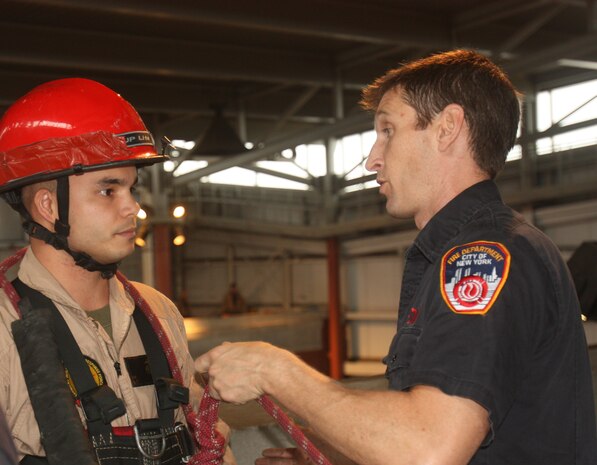 Randall’s Island, NEW YORK – A firefighter and instructor with the New York City Fire Department explains to Sergeant Daniel Barbadillo, an extraction Marine with Initial Response Force “B,” how he will repel down two stories to rescue a “stranded victim” from a ledge and get them safely to the ground. The FDNY has been involved in training the Mariens and sailors of CBIRF since 1997, when Chief Raymond Downey helped expand CBIRF’s technical rescue platform.