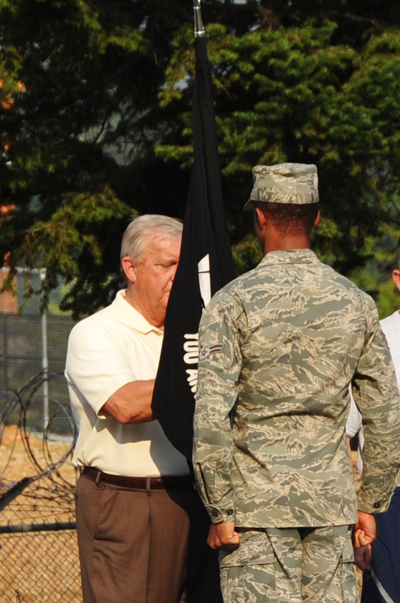 The ninth Chief Master Sgt. of the Air Force James C. Binnicker accepts the Prisoner of War/Missing in Action guideon from Airman 1st Class David Duffus during a symbolic retreat ceremony at Osan Air Base, Republic of Korea, Sept. 20, 2012. Binnicker provided mentorship and guidance to Airmen during his two-day visit to the base. Duffus is with the 25th Fighter Squadron Aviation Resource Management office. (U.S. Air Force photo/Staff Sgt. Craig Cisek)