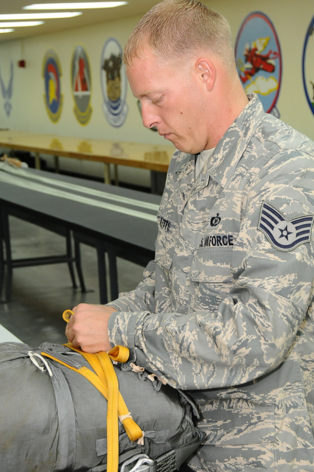 ANDERSEN AIR FORCE BASE, Guam – Staff Sgt. Christopher Kitts, 36th Operations Support Squadron aircrew flight equipment specialist, secures the static line cord into the parachute back, Sept. 11. The static line is what will be connected to the aircraft before the jumper or cargo pallet vacates the aircraft, using the plane to pull out the parachute. (U.S. Air Force photo by Senior Airman Carlin Leslie/Released)