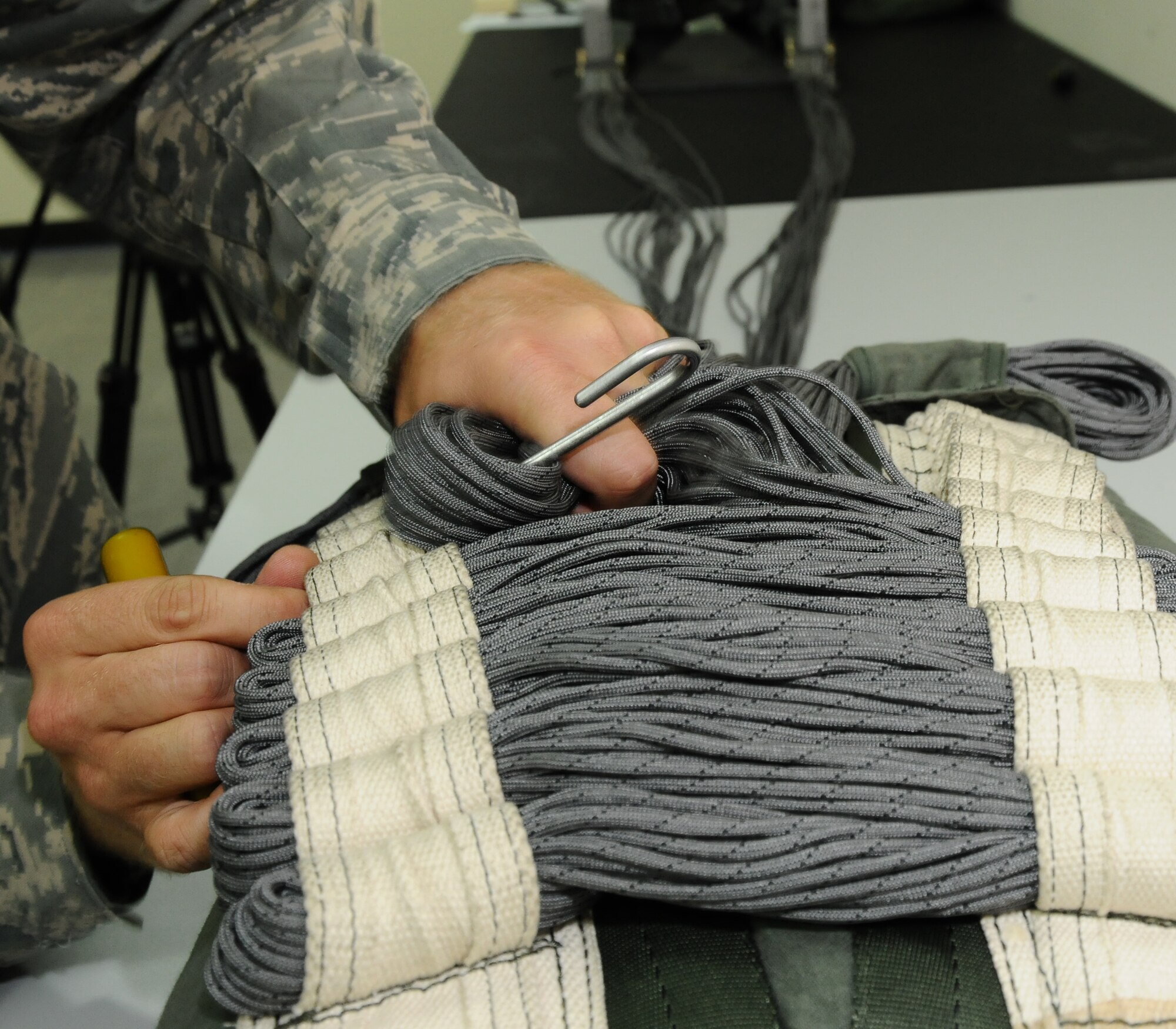 ANDERSEN AIR FORCE BASE, Guam – Canopy lines are pulled through loops on the back of the parachute, Sept. 11. Securing the lines in the stowing line loops makes them less likely to get tangled upon deployment of the chute. (U.S. Air Force photo by Senior Airman Carlin Leslie)