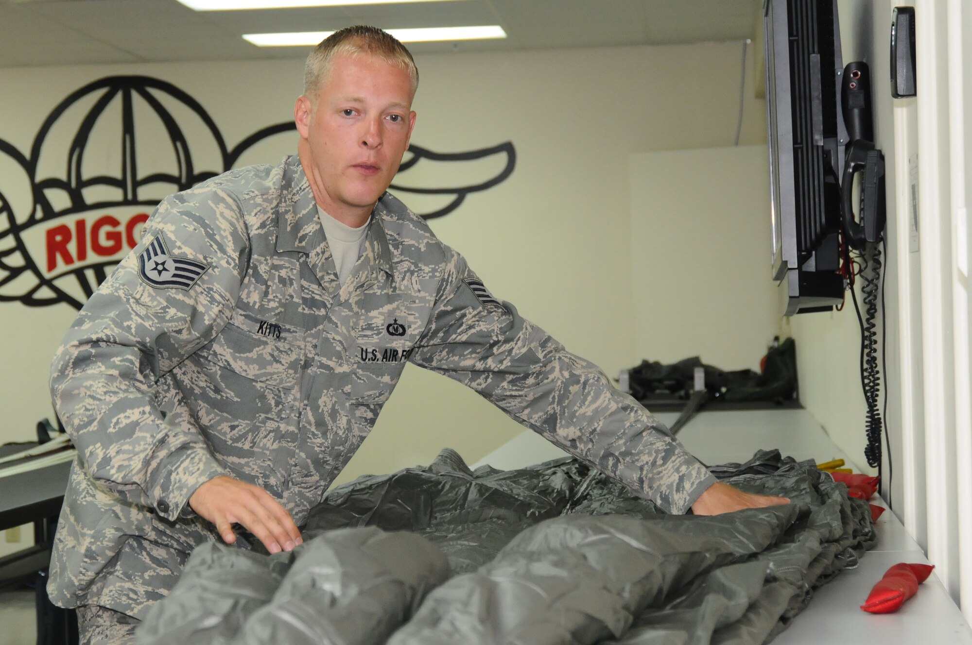 ANDERSEN AIR FORCE BASE, Guam – Staff Sgt. Christopher Kitts, 36th Operations Support Squadron aircrew flight equipment specialist flattens out the folded parachute prepping it for the final pack, Sept. 11. Every step of the packing procedure much be accomplished with 100 percent accuracy. (U.S. Air Force photo by Senior Airman Carlin Leslie)