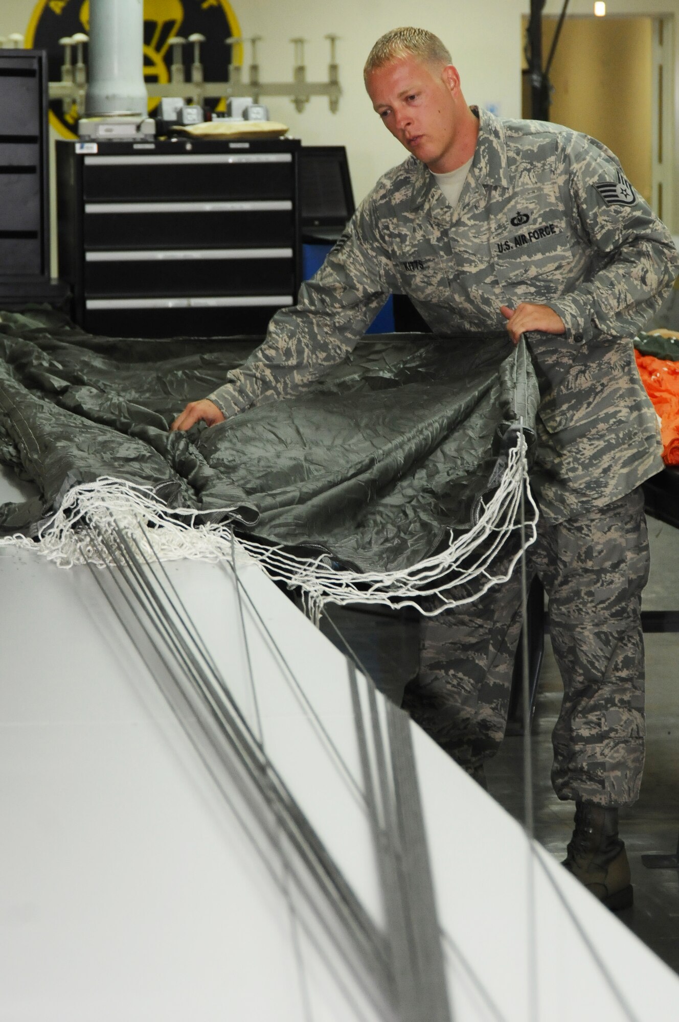 ANDERSEN AIR FORCE BASE, Guam – Staff Sgt. Christopher Kitts, 36th Operations Support Squadron aircrew flight equipment specialist, checks over a parachute, Sept. 11. Sgt Kitts is inspecting for rips and tears or torn lines at the bottom of the chute.  (U.S. Air Force photo by Senior Airman Carlin Leslie) 