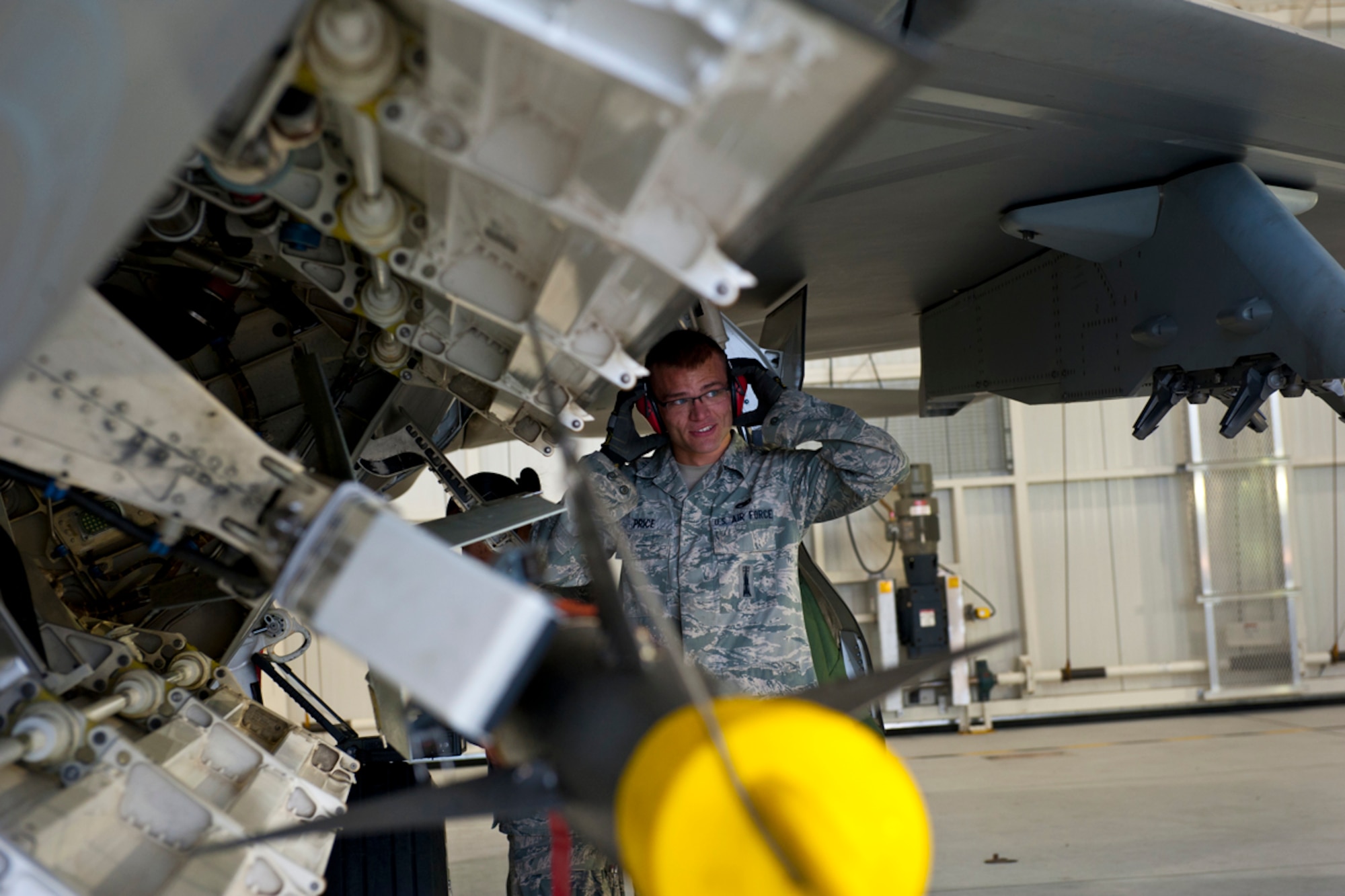 JOINT BASE ELMENDORF-RICHARDSON, Alaska -- Air Force Staff Sgt. Jacob Price, an aircraft systems speacialist with the 90th Air Craft Mainenence Unit, looks up from examining an air intercept missile 9 at the 90th Fighter Squadron, August 20, 2012.  The load competitiong  began as a load competition transformed into an excersize.  (U.S. Air Force Photo/ Airman 1st Class Omari Bernard)
