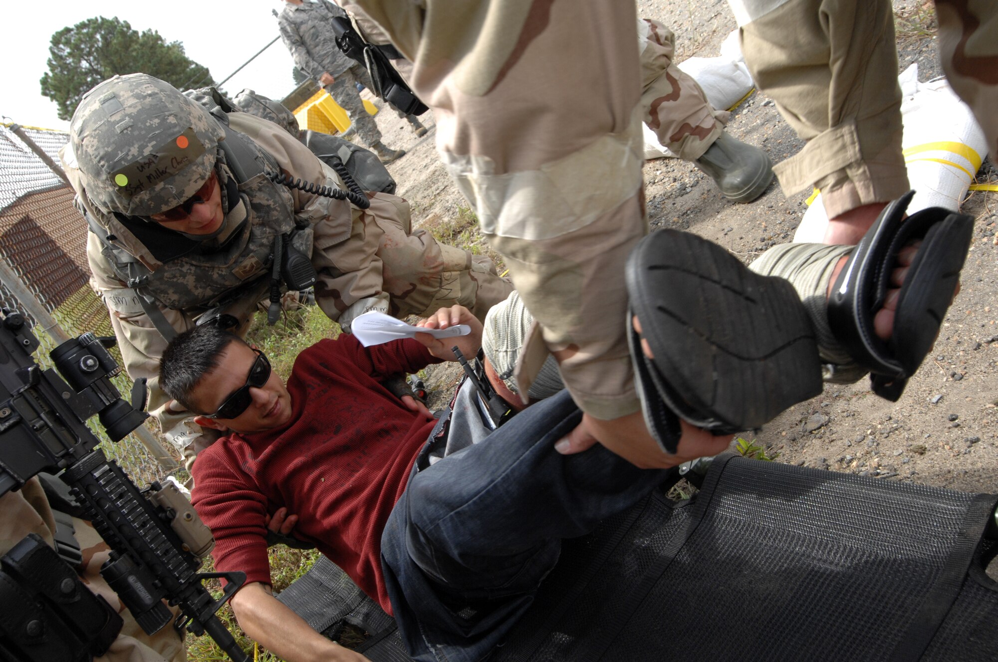 U.S. Air Force Airmen assigned to the 4th Security Forces Squadron transfer a moulage patient onto a litter during an attack as part of Operational Readiness Exercise Coronet Warrior 12-04 at Base X on Seymour Johnson Air Force Base, N.C., Sept. 20, 2012. Evaluators tested the ability of security forces personnel to react to medical emergencies while under direct fire. (U.S. Air Force photo/Airman 1st Class Aubrey Robinson/Released)