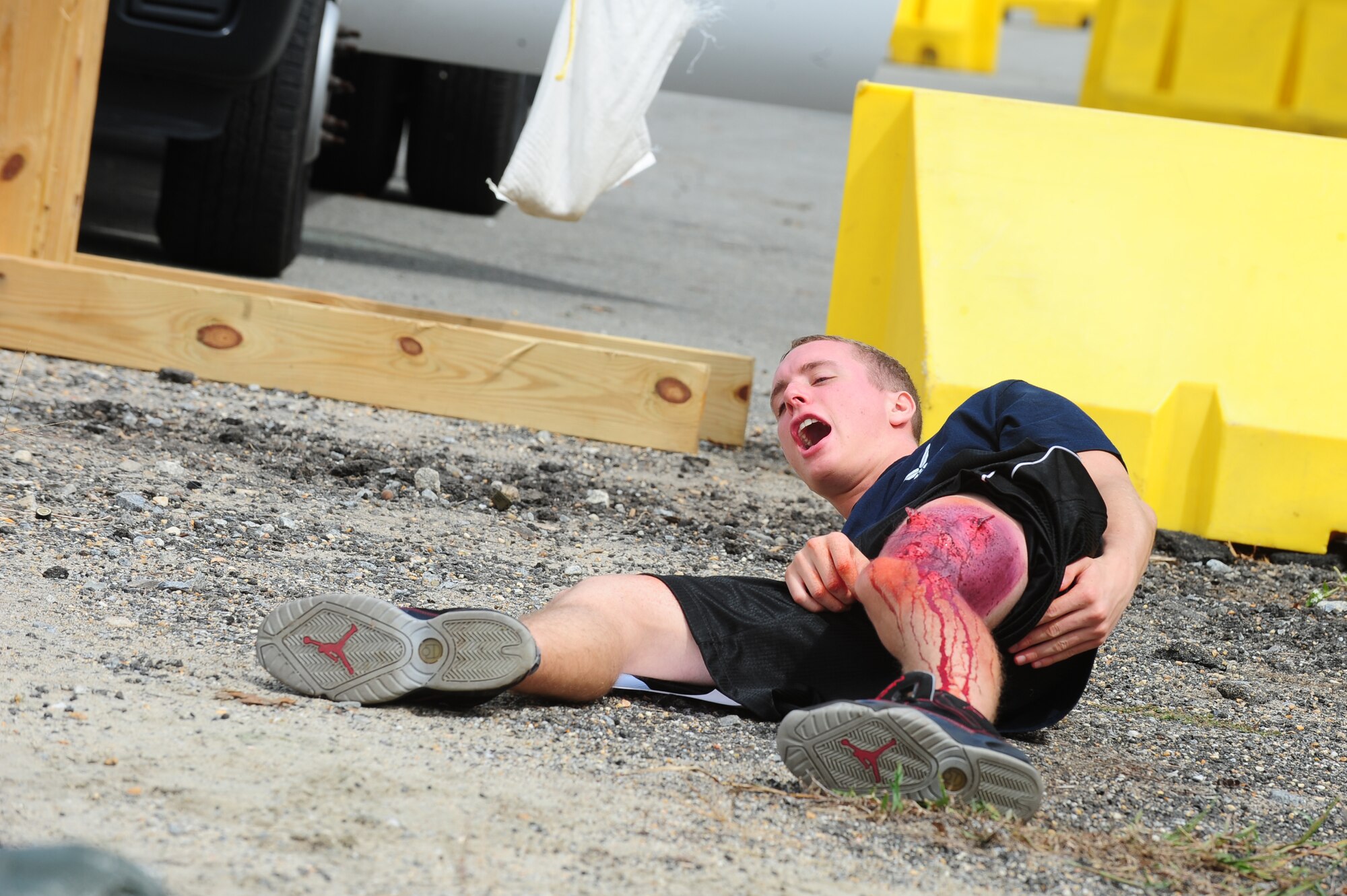 A U.S. Air Force Airman assigned to the 4th Fighter Wing calls for help during a simulated attack during Operational Readiness Exercise Coronet Warrior 12-04 at Base X on Seymour Johnson Air Force Base, N.C., Sept. 20, 2012. Moulage patients, or personnel with mock injuries, were used frequently during the exercise to make scenarios more realistic. (U.S. Air Force photo/Airman 1st Class Aubrey Robinson/Released)