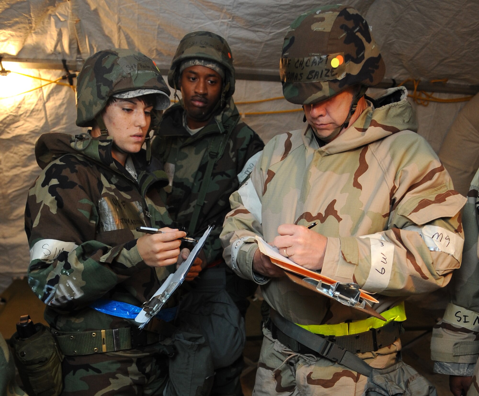 U.S. Air Force Airmen assigned to the 4th Medical Operations Squadron watch as Capt. Thomas Baize, 4th Fighter Wing Chaplain, signs a document after patient visitation during Operational Readiness Exercise Coronet Warrior 12-04 at Base X on Seymour Johnson Air Force Base, N.C., Sept. 20, 2012. As a part of their duties, Chaplains must make periodic visits to hospital patients and offer prayer services according to patients' religious preferences. (U.S. Air Force photo/Airman 1st Class Aubrey Robinson/Released)