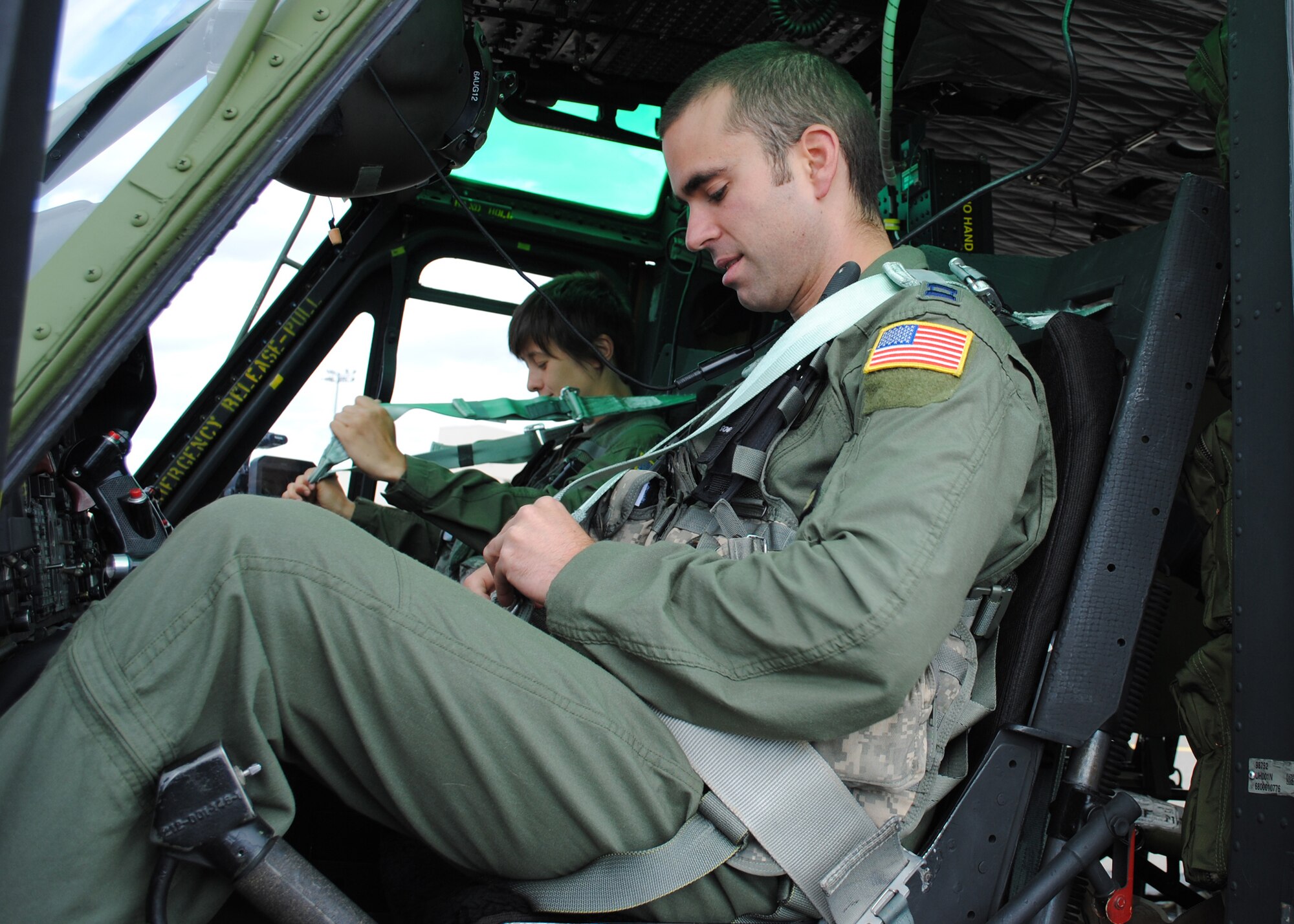 Tope and Struber strap themselves into a helicopter during a preflight inspection. The success of this aircrew in the Global Strike Challenge relies heavily on how well they work together. (U.S. Air Force photo/Airman 1st Class Katrina Heikkinen)