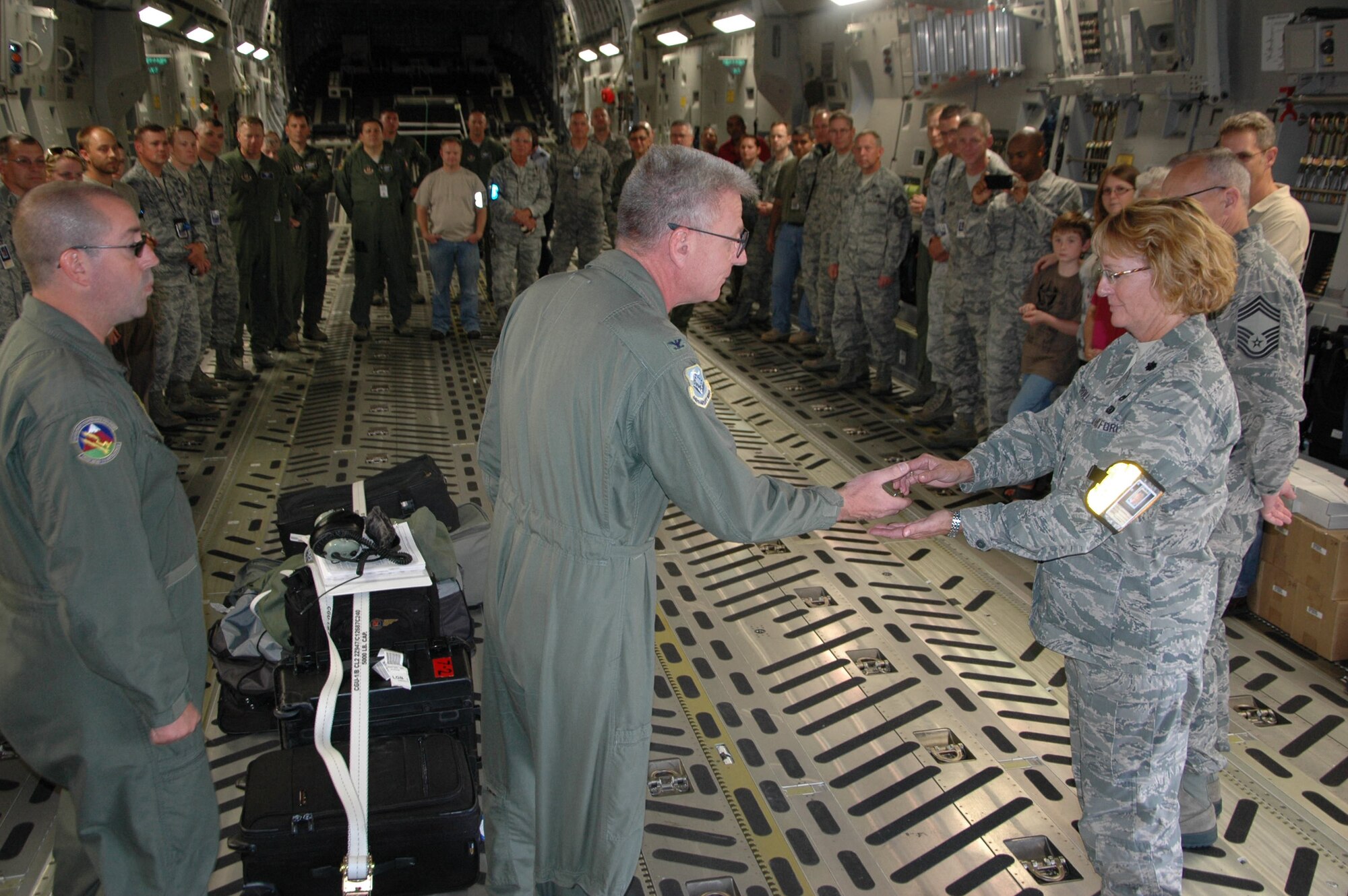 Col. Bruce Bowers, 446th Airlift Wing commander, turns over the "keys" to P-218, McChord's newest C-17, to Lt. Col. Maureen Carroll, 446th Maintenance Squadron commander. Colonel Bowers flew the aircraft from the Boeing plant in Long Beach, Calif. to McChord Sept. 14. The 446th AW is an Air Force Reserve wing at McChord Field, Wash., sharing global airlift missions with the 62nd AW, the aircraft-owning unit. With three C-17 flying squadrons, the 2,300-strong wing provides aircrews and support on a daily basis to execute the Air Force's global airlift mission. (U.S. Air Force photo by Sandra Pishner)