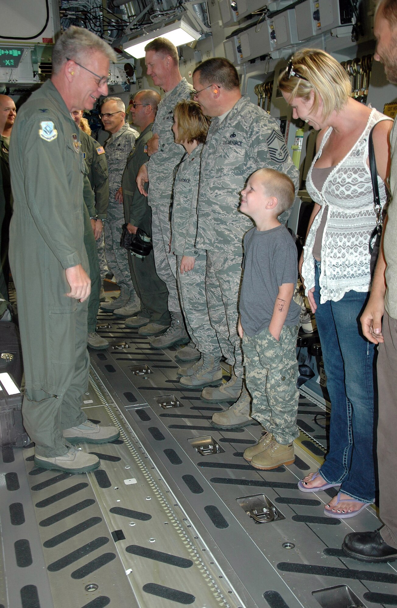 Col. Bruce Bowers, 446th Airlift Wing commander (left), talks to Logan Chop, son of Tech Sgt. Michael Chop, 446th Aircraft Maintenance Squadron, after delivering P-218, the newest C-17 to  McChord Field, Wash. Sergeant Chop served as the flying crew chief on the aircraft's flight Sept. 14 from Long Beach, Calif., to McChord. The 446th AW is an Air Force Reserve wing here, sharing global airlift missions with the 62nd AW, the aircraft-owning unit. With three C-17 flying squadrons, the 2,300-strong wing provides aircrews and support on a daily basis to execute the Air Force's global airlift mission. (U.S. Air Force photo by Sandra Pishner)